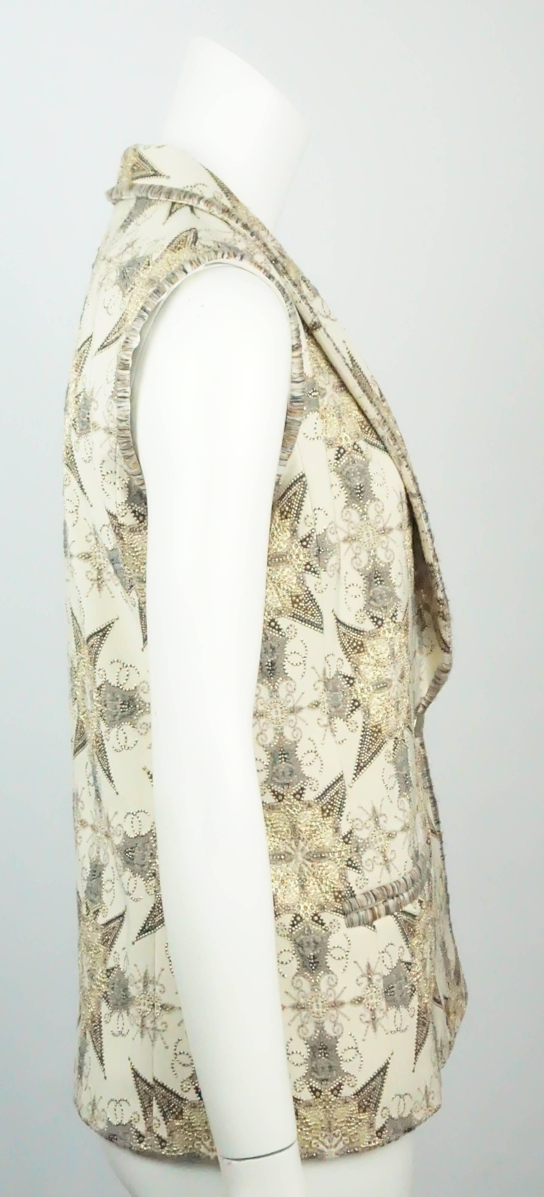 Chanel Cream and Metallic Silk Lined Brocade Vest-38-NWT  This beautiful and festive cream vest has Gold, and Earthtone Brocade and threading throughout with an ornate design. It has one front gold button and two illusion pockets. The vest has a