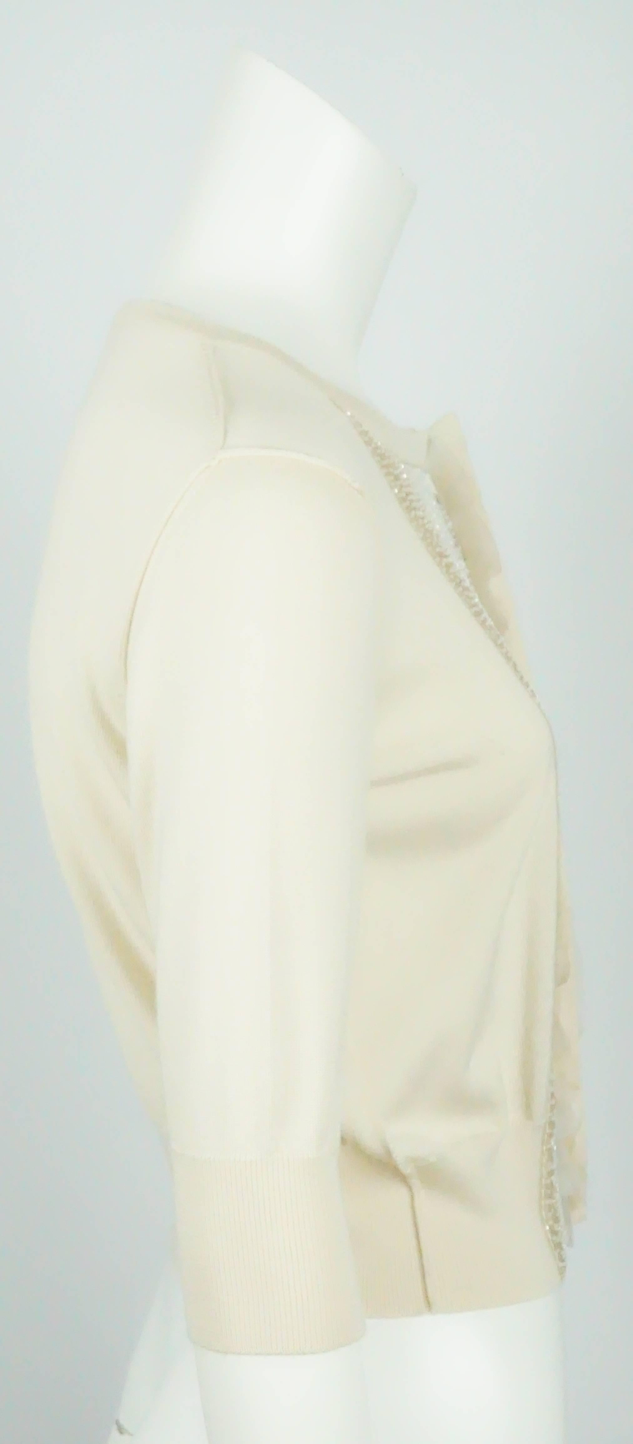 Oscar de La Renta Beige Cashmere 3/4 sleeve Beaded Sweater - M  This beautiful 3/4 sleeve cashmere sweater has white and silver beads and sequin along the front of the sweater with 2 layers of silk organza as well. The sweater has 6 pearl buttons