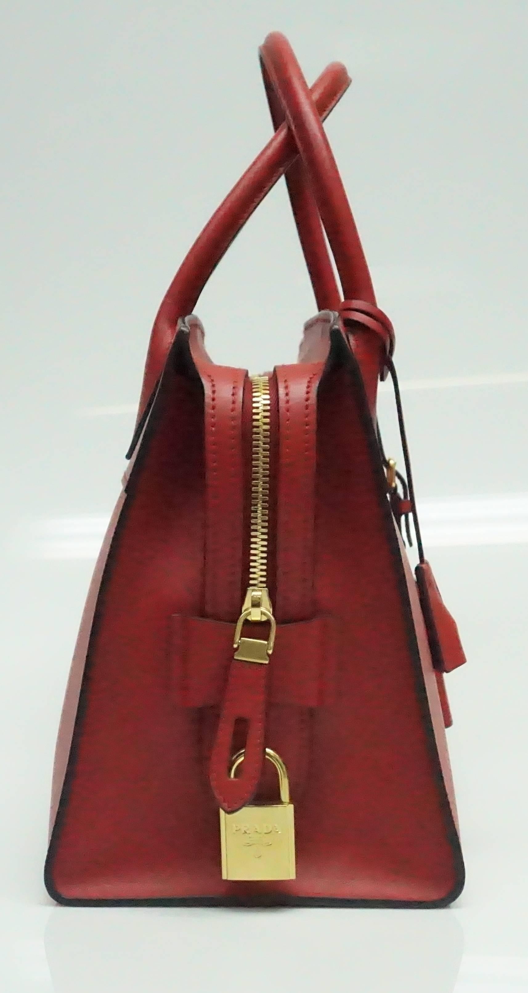 Prada Red Saffiano City Handbag - NEW  This new and still in stores fabulous red handbag by Prada is just the right pop of color. The bag has a top handle and a detachable shoulder strap so that you can wear over the shoulder or as a crossbody. The