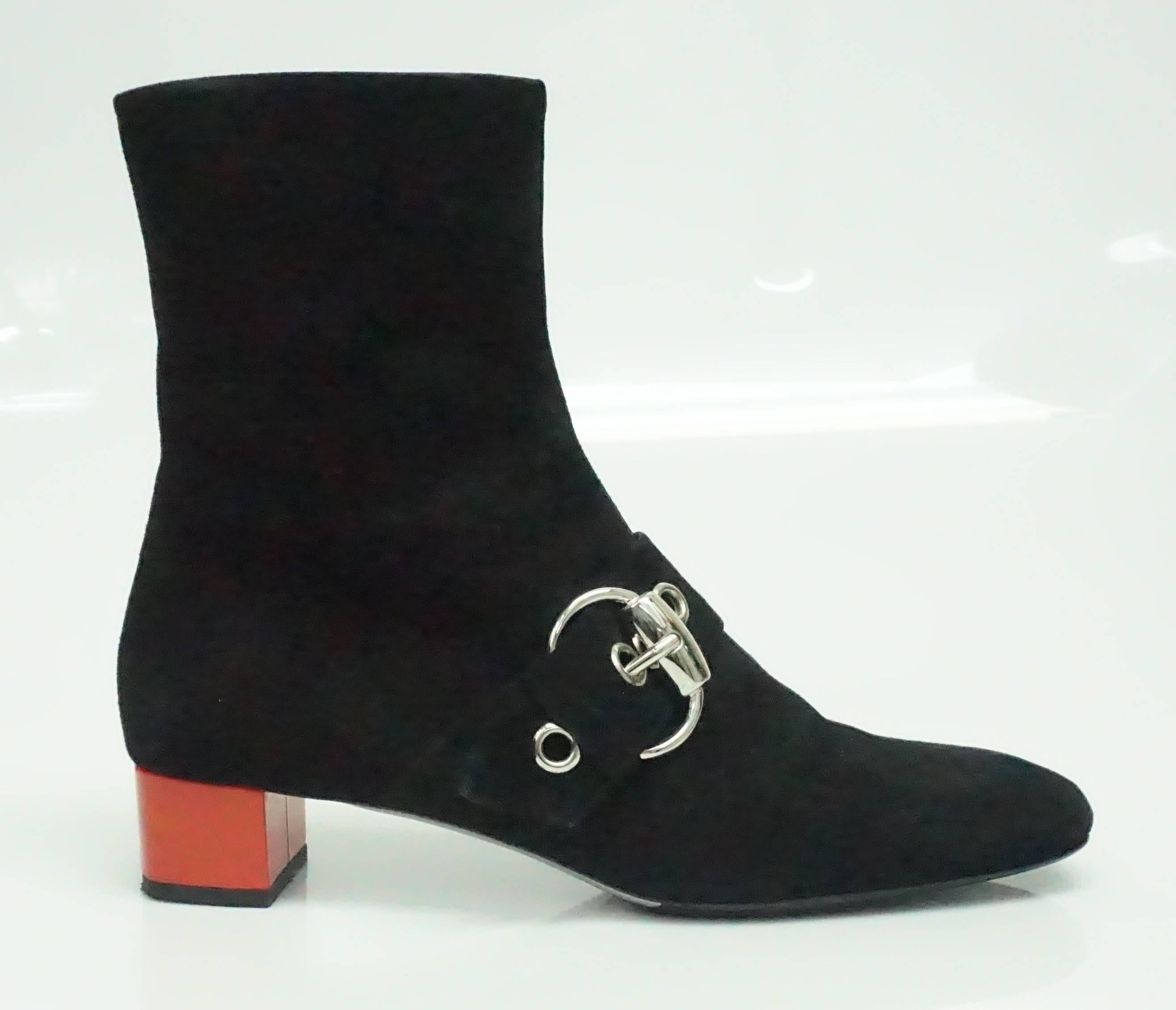 Gucci Black Suede Short Boot with Red Patent Chunky Heel - SHW - 39C  This is truly one of my favorite Gucci Boots I have seen. The black suede boot  has a somewhat rounded toe, a strap that comes across the is accented by a silver buckle and