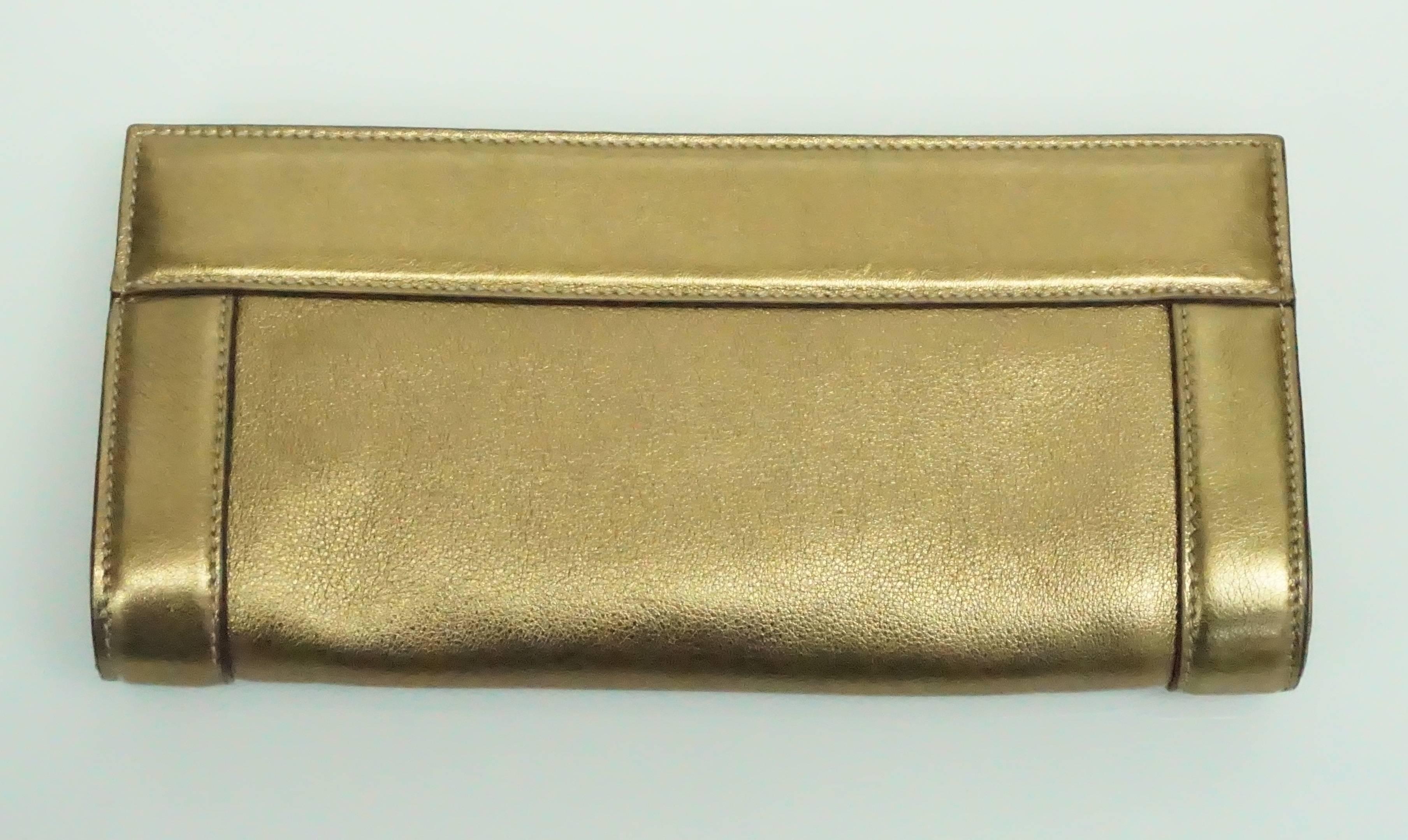 Gucci Bronze Leather and Gold Hardware Britt Clutch  This wonderful Bronze leather clutch has the top gold framing with two turnkey locks to secure the bag shut. It has a large GG also in the same gold hardware on the front of the bag. It has one