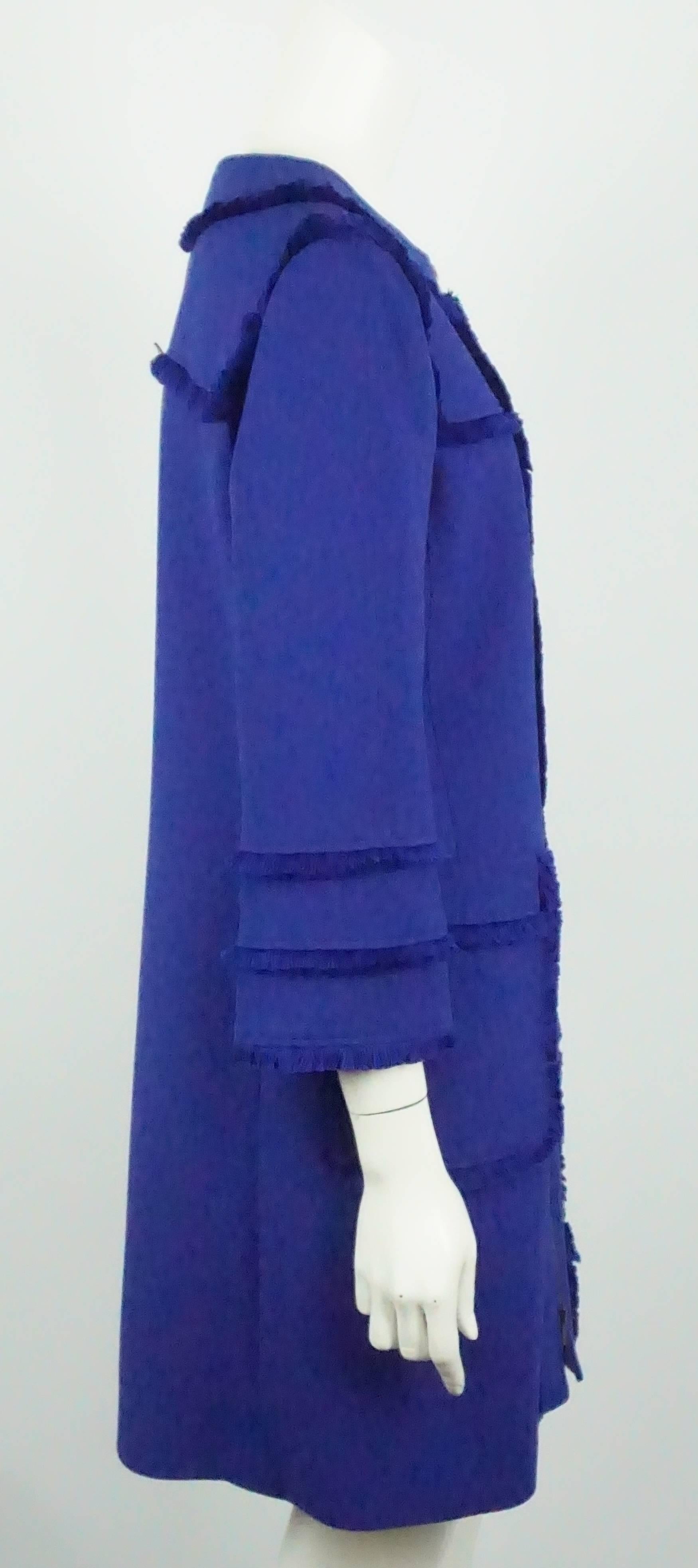 Andrew GN Royal Blue Wool Coat with Fringe - 42  This coat has a beautiful royal blue color in wool. It has a front zip, 2 front pockets trimmed in fringe, bracelet sleeve and lined in silk. The coat is in excellent condition, only worn