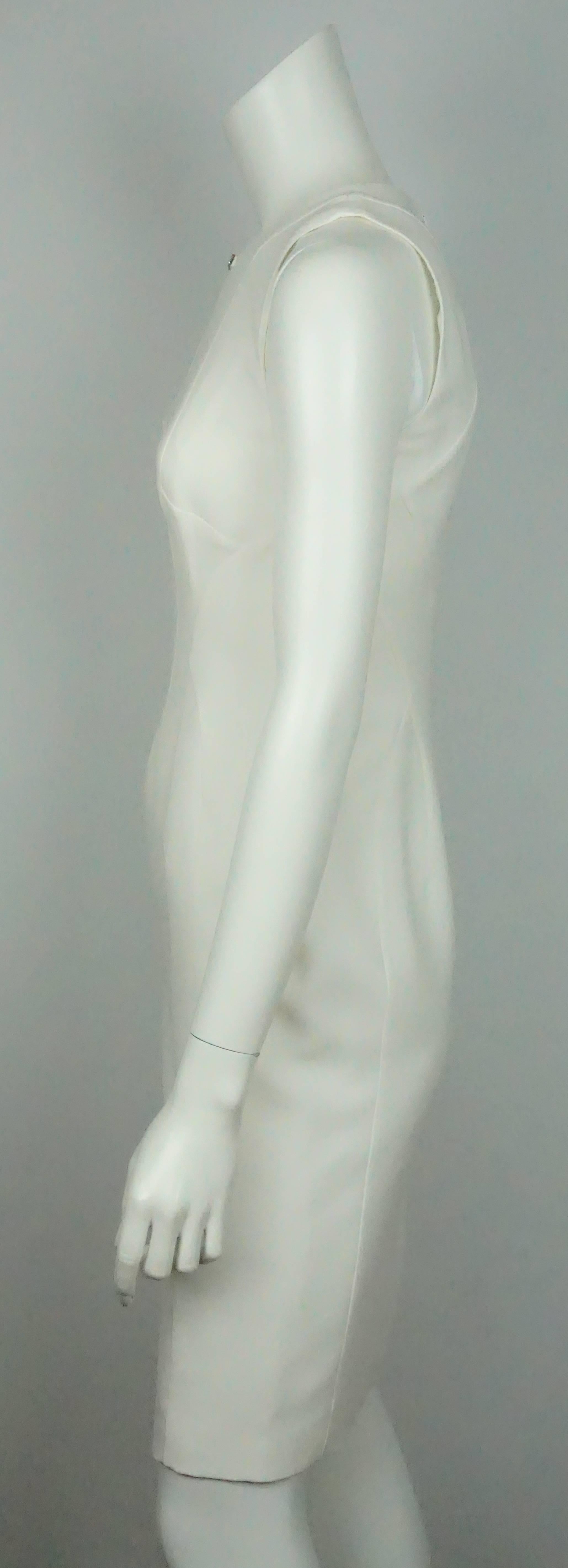 Versace Ivory Silk Sleeveless Dress - 38   This simple yet stunning silk dress is in excellent condition. The dress has deep v neckline that is connected by a rectangular jeweled detail. The dress is sleeveless and has a geometric look to it by the