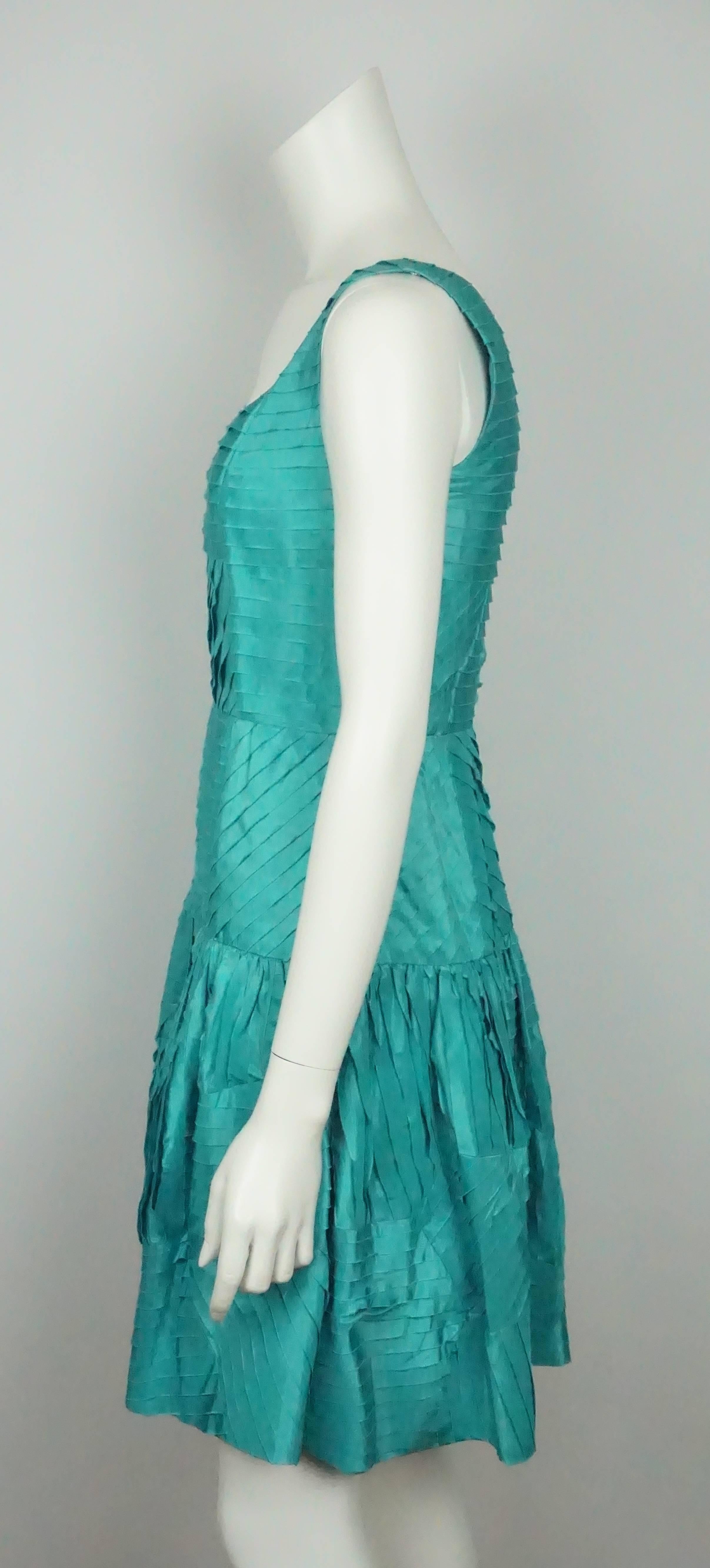 Oscar De La Renta Teal Silk Shutter Pleat Dress - 4  This classic and elegant Oscar creation is made of a beautiful Teal colored raw silk . The dress is sleeveless with a square neckline and is fitted to below the waist. It is all shutter pleats and