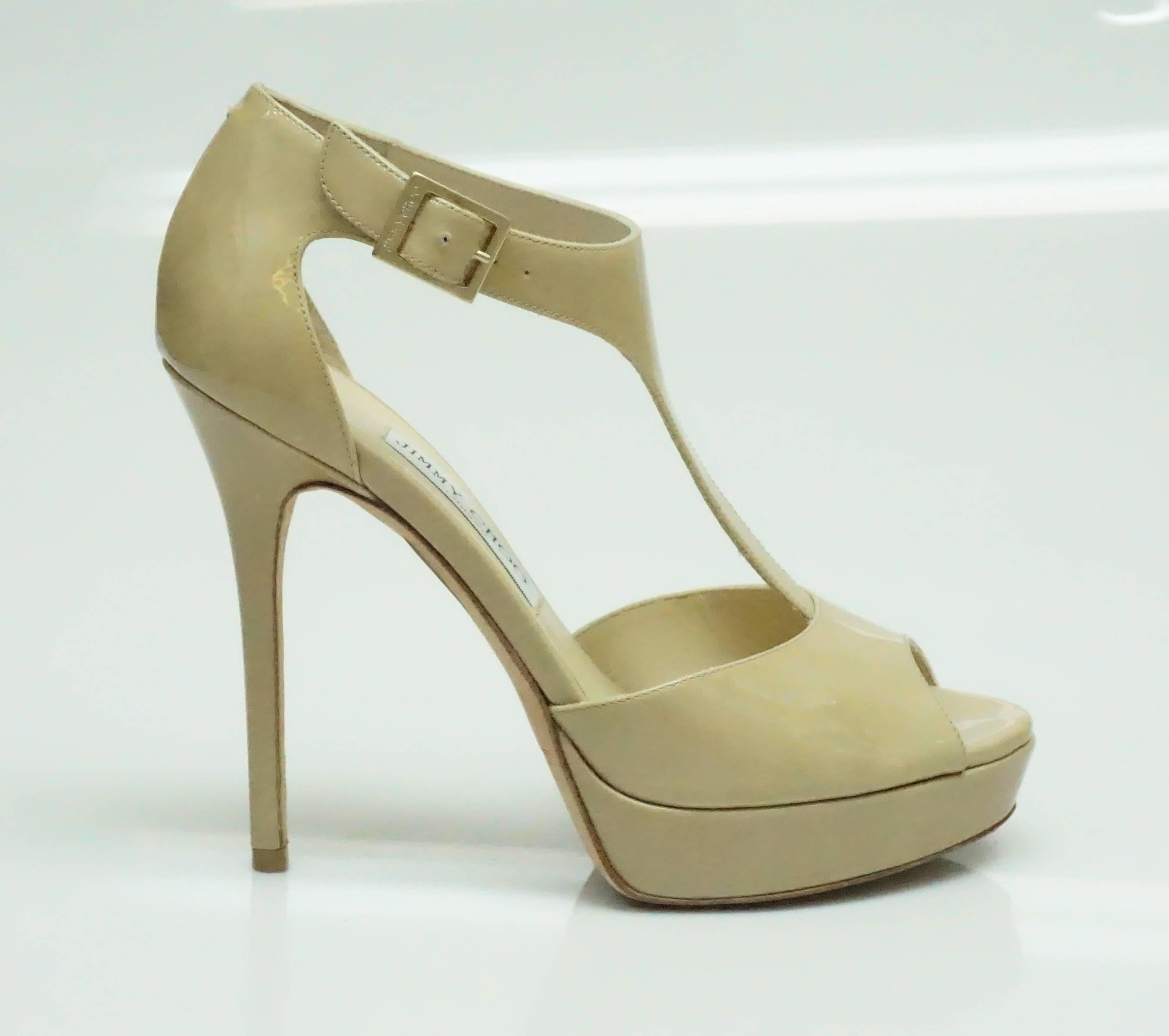 Jimmy Choo Nude Patent Platform Sandal - 38.5  These classic heels are in good condition. They have a bit of wear in the sole of the shoe and some discoloration around the toe of the shoe. The heel has an ankle strap that attaches to the front of