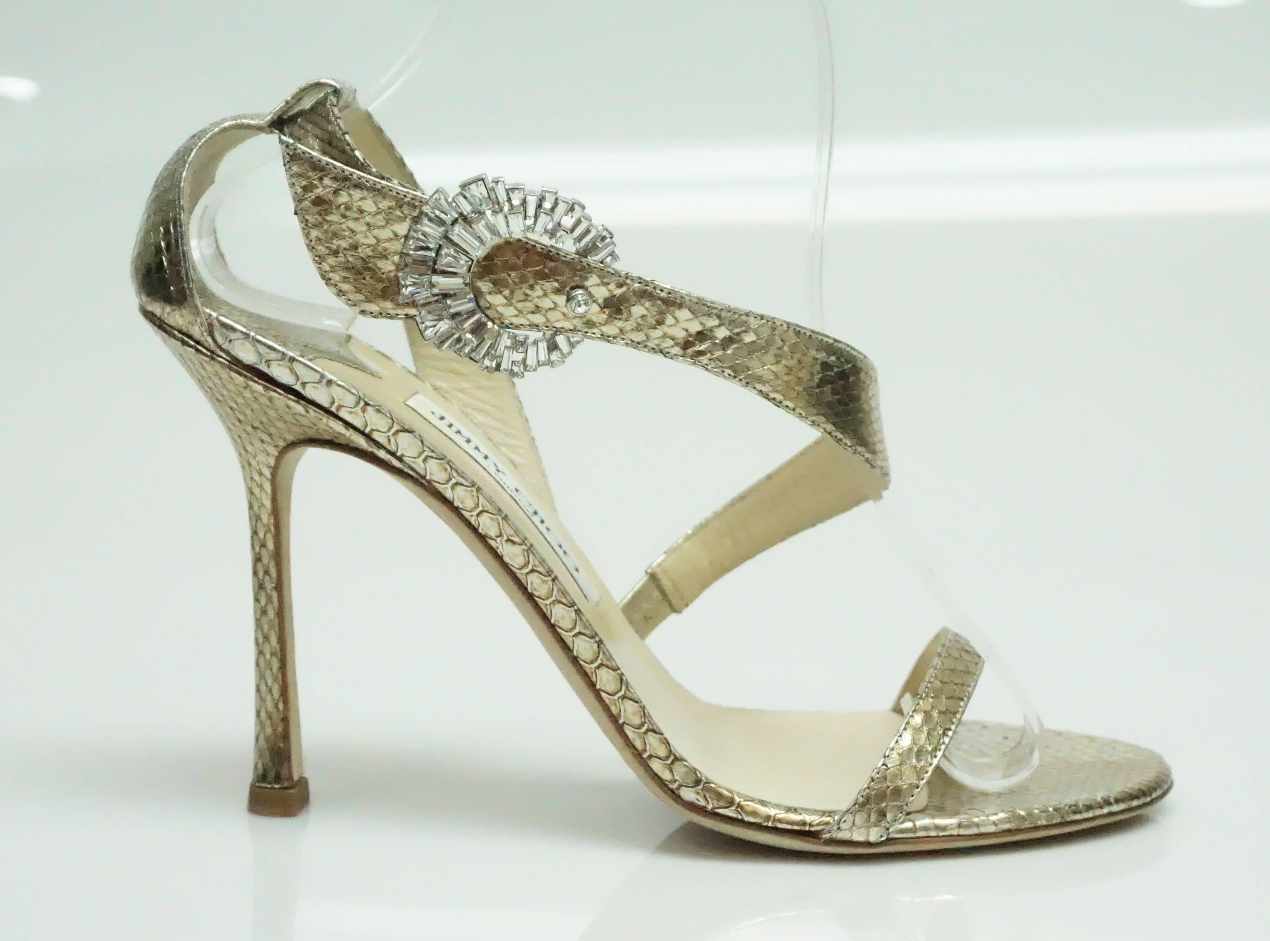 Jimmy Choo Gold Watersnake Sandal w/ Swarovski Buckle - 39 - NEW?NEVER WORN These stunning heels have never been worn before. They have a beautiful wrap around strap that is embellished with a swarovski buckle that is in a circle shape.