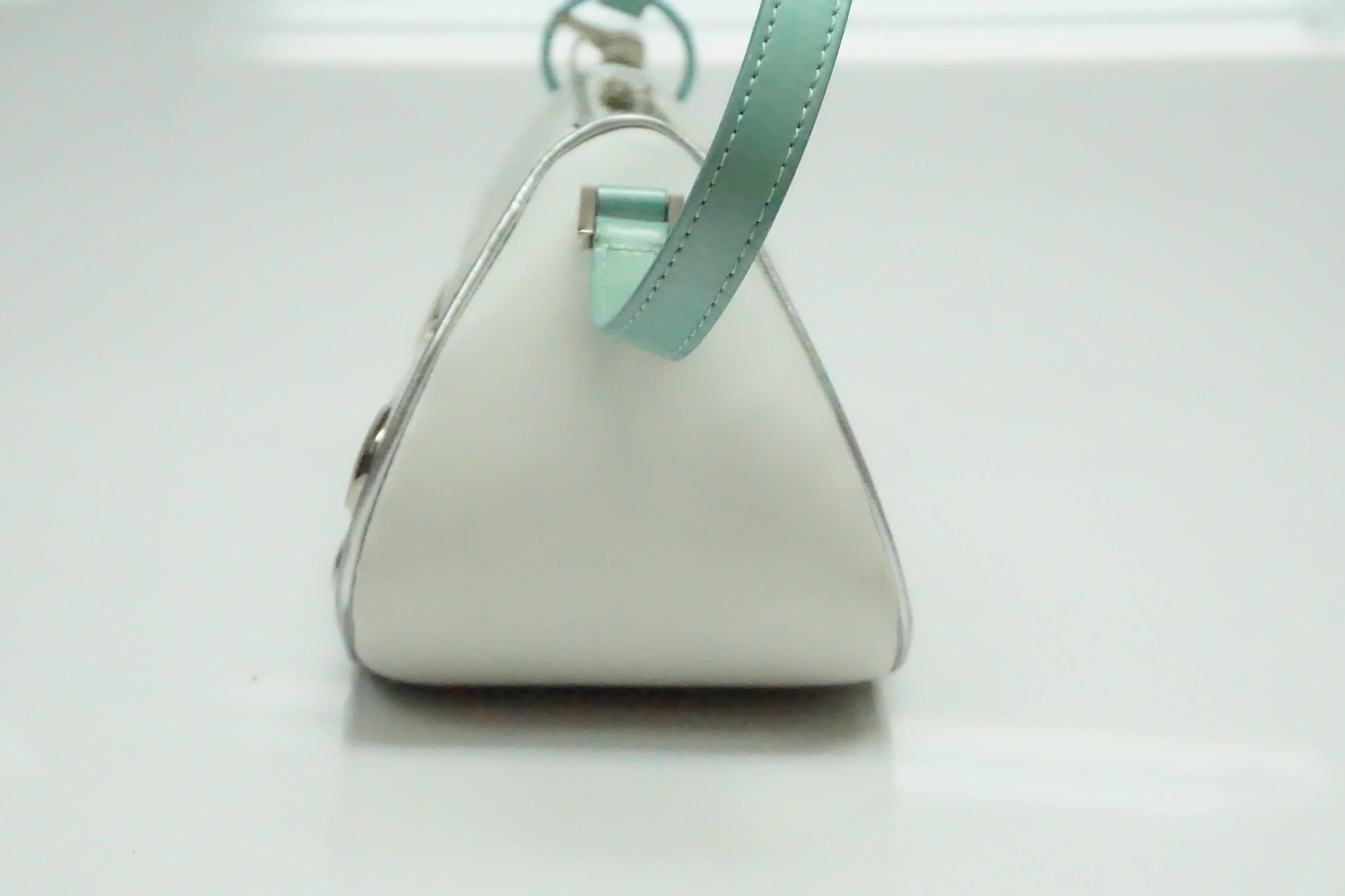 Christian Dior White and Teal Leather Handbag  This very special handbag is in excellent condition. The front and the back has a quilt detail on the white leather. On the front, on the teal part, there is a metal plate that imitates a license plate.