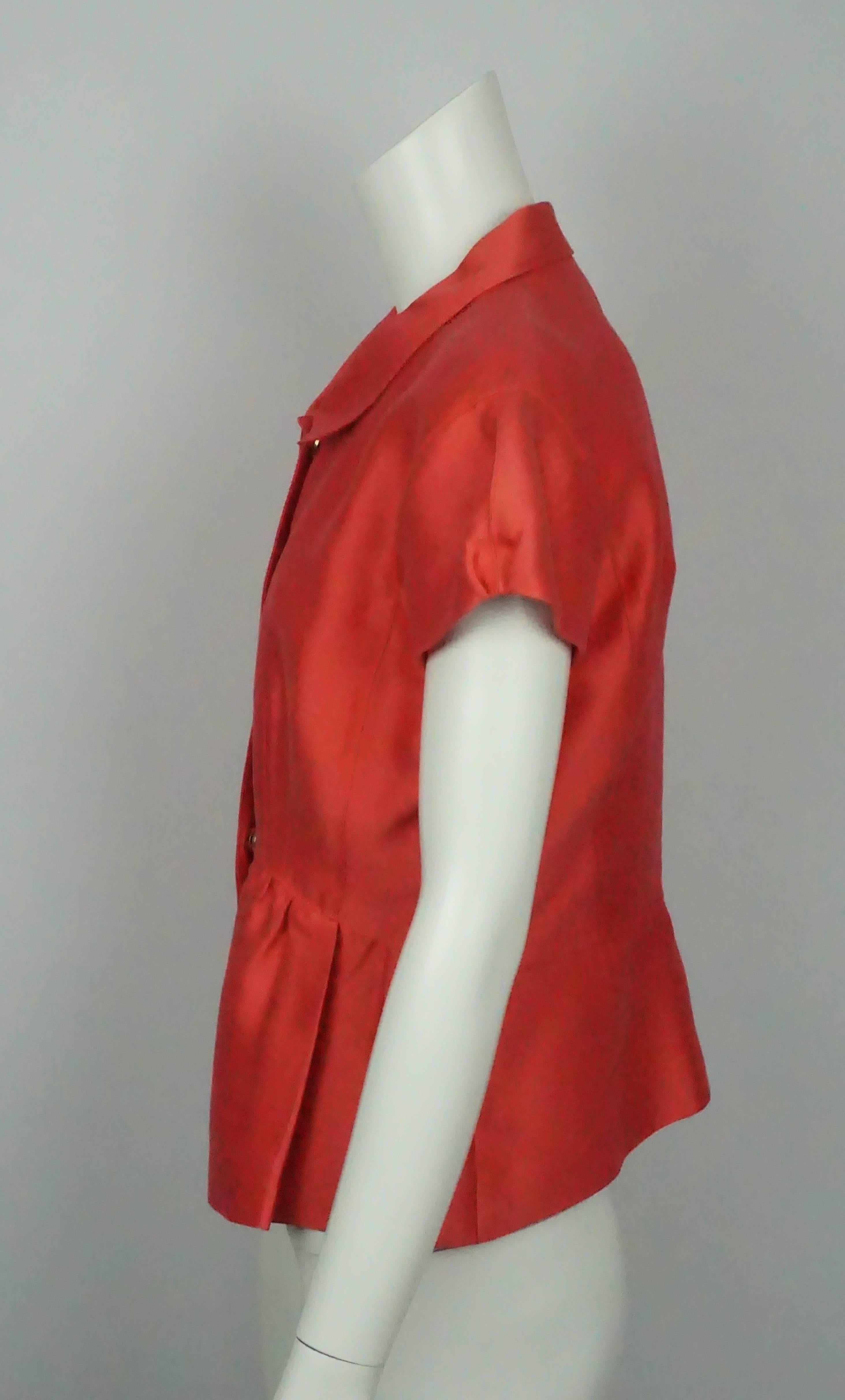 Oscar De La Renta Coral Cotton/Silk Blend S/S Top - 8 This classic Oscar cotton top is in excellent  condition. The top has a cap sleeve and a slight peplum to it. There are five metal snaps that are hidden down the front center of the jacket. This