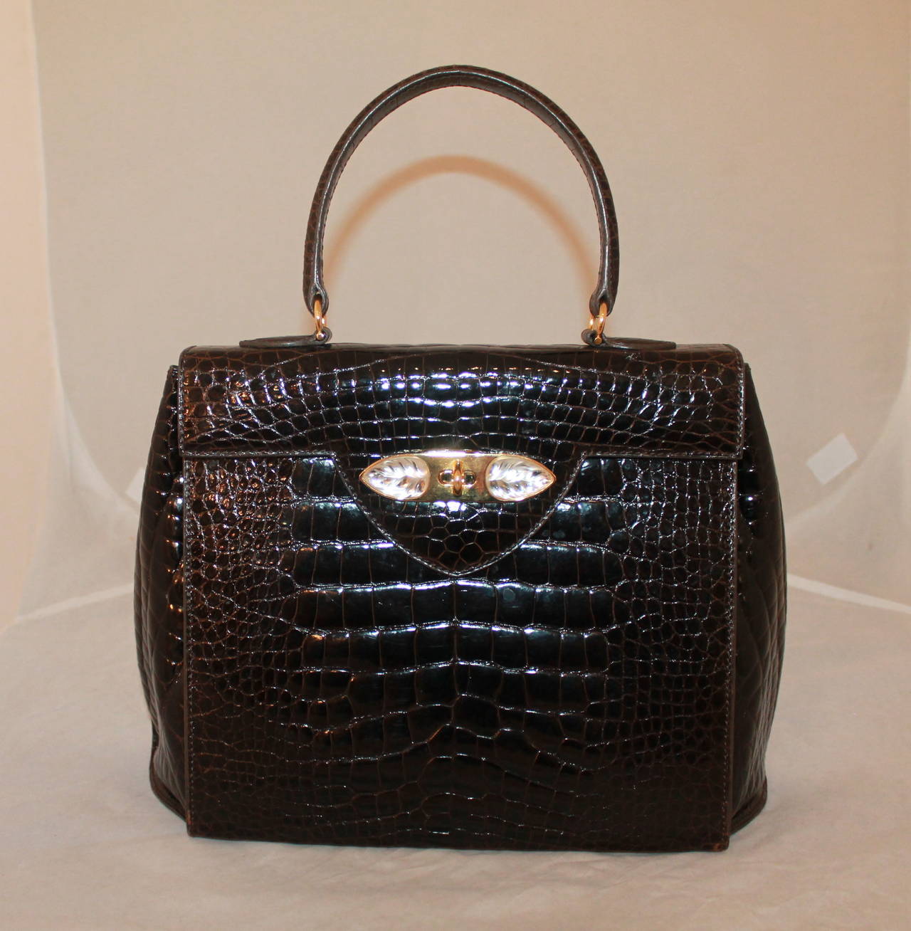 Lalique 1990's Chocolate Brown Croc Handbag with Lucite Detail - GHW. This bag is in very good condition with nearly no wear. It is a truly unique piece.

Measurements:
Length- 9.25"
Width- 13"
Depth- 4"
Handle Drop- 5"