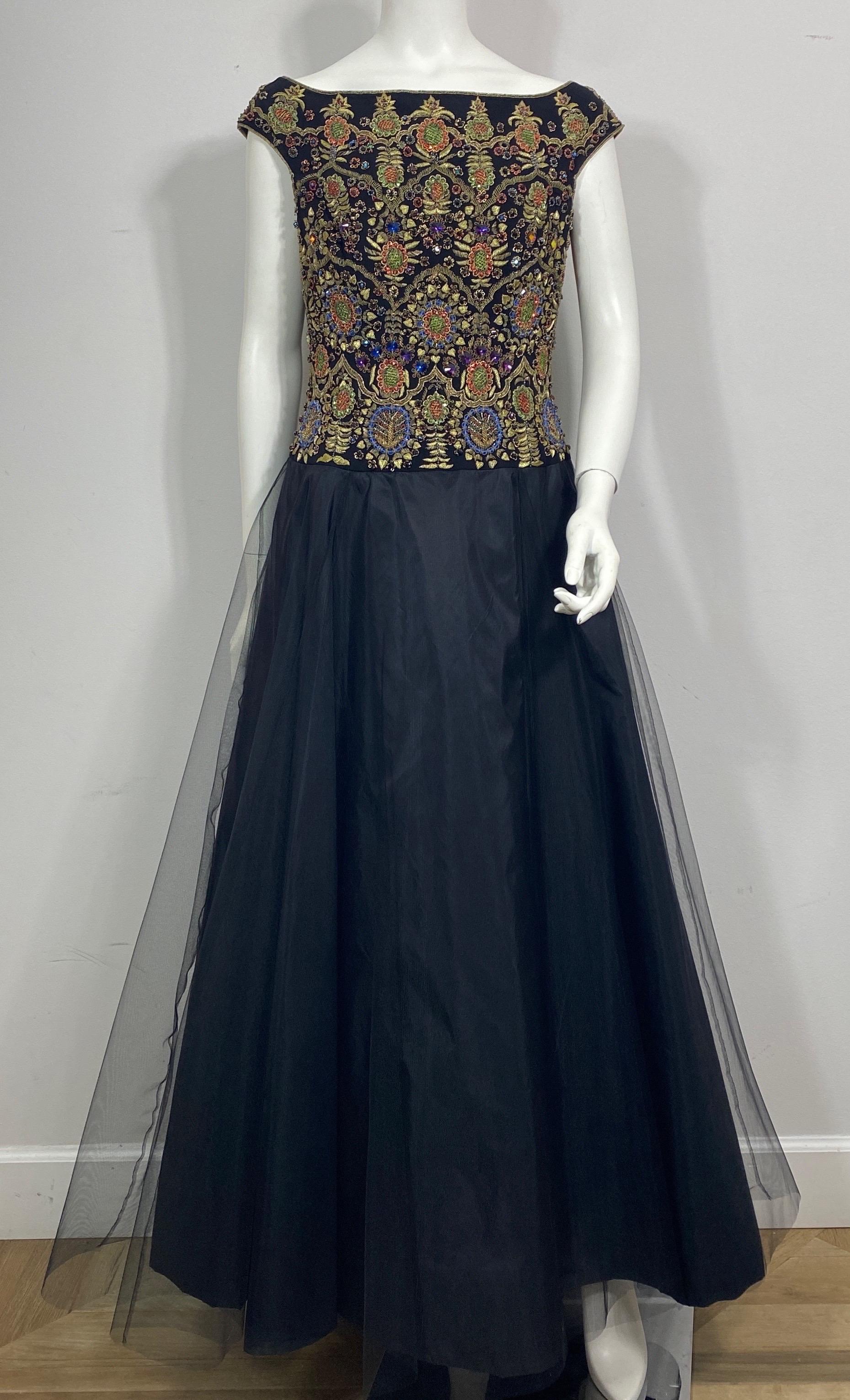 Escada Black Silk Sleeveless Gown w/ Multi Colored Beaded Bodice and a multi layer tulle skirt is a size 38.  This 1990’s striking gown is in excellent condition.  It features a gorgeous black silk material, intricate multi colored beaded, gemstone