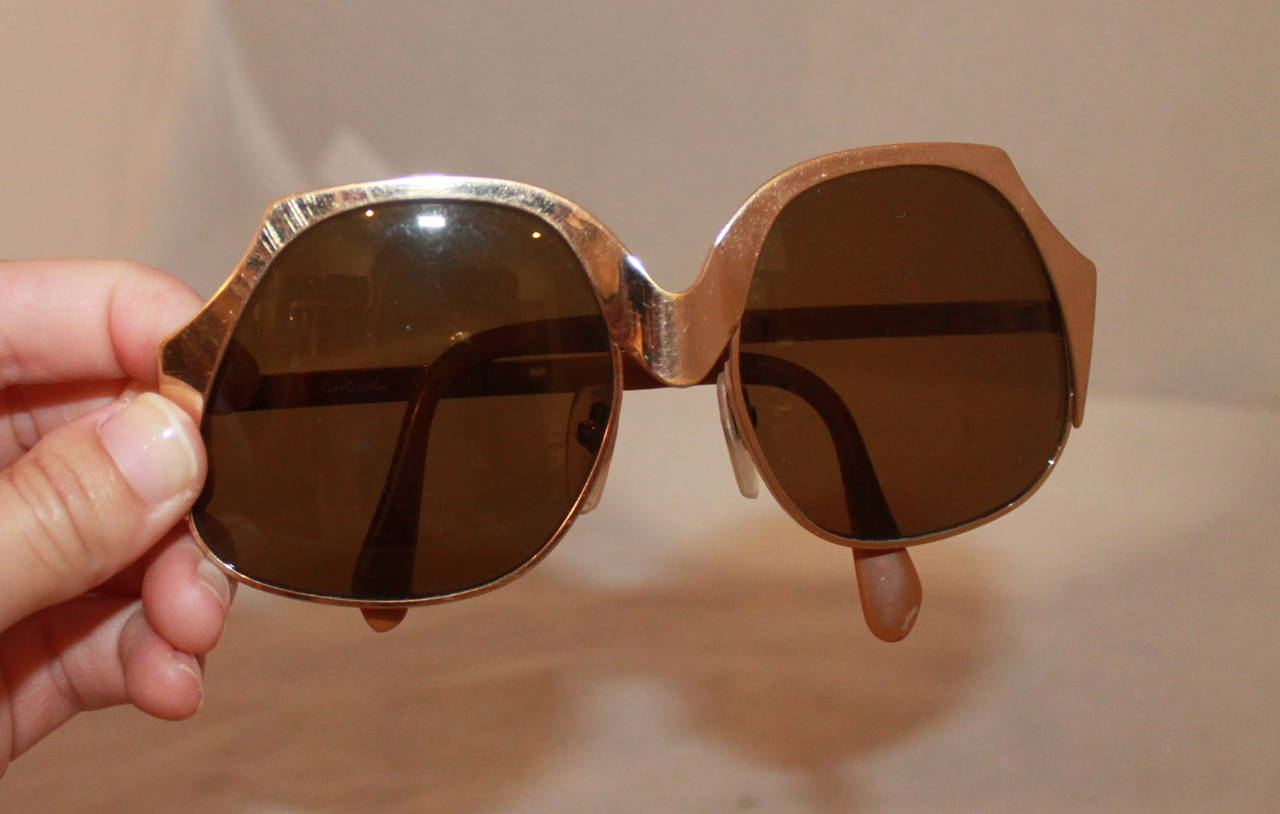 1960's Vintage Gold Geometric Sunglasses. These unique sunglasses are in good vintage condition and have wear consistent with its age. The lenses are a medium brown and have minor scratching.

Measurements:
Length of both lenses- 5.75