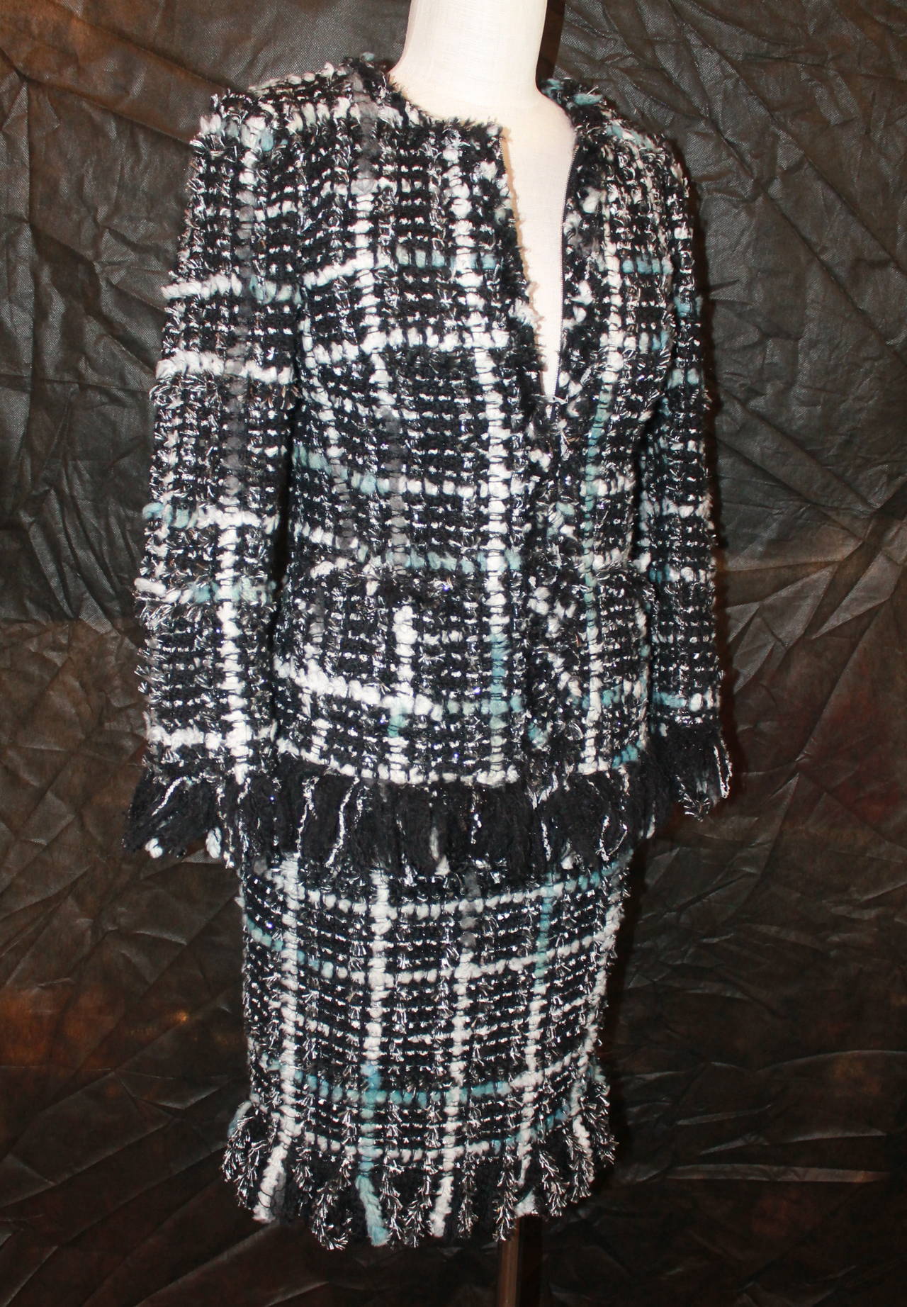 Chanel Blue, Silver, Black Tweed Skirt Suit with Fringe - 34 - cc 2013. This set is in excellent condition with no visible signs of wear. The skirt has a band at the waist and the jacket zips up. The jacket also has 2 pockets.