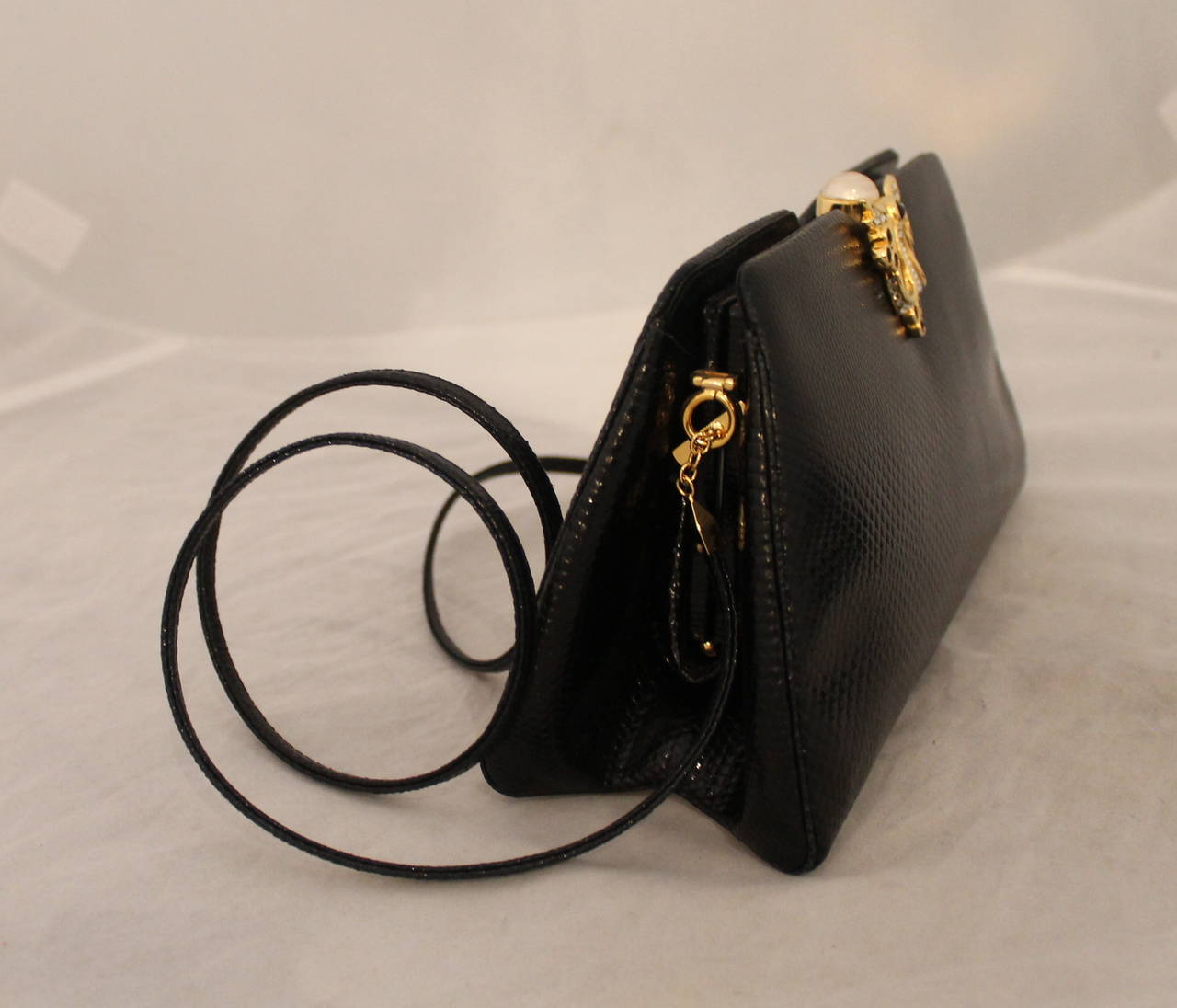 Judith Leiber 1980's Vintage Black Lizard Evening Bag with Pearl & Rhinestone Clasp. This bag comes with the duster, comb, compact, compact cover, and original cards. It is in excellent condition. 

Measurements:
Length- 4.75