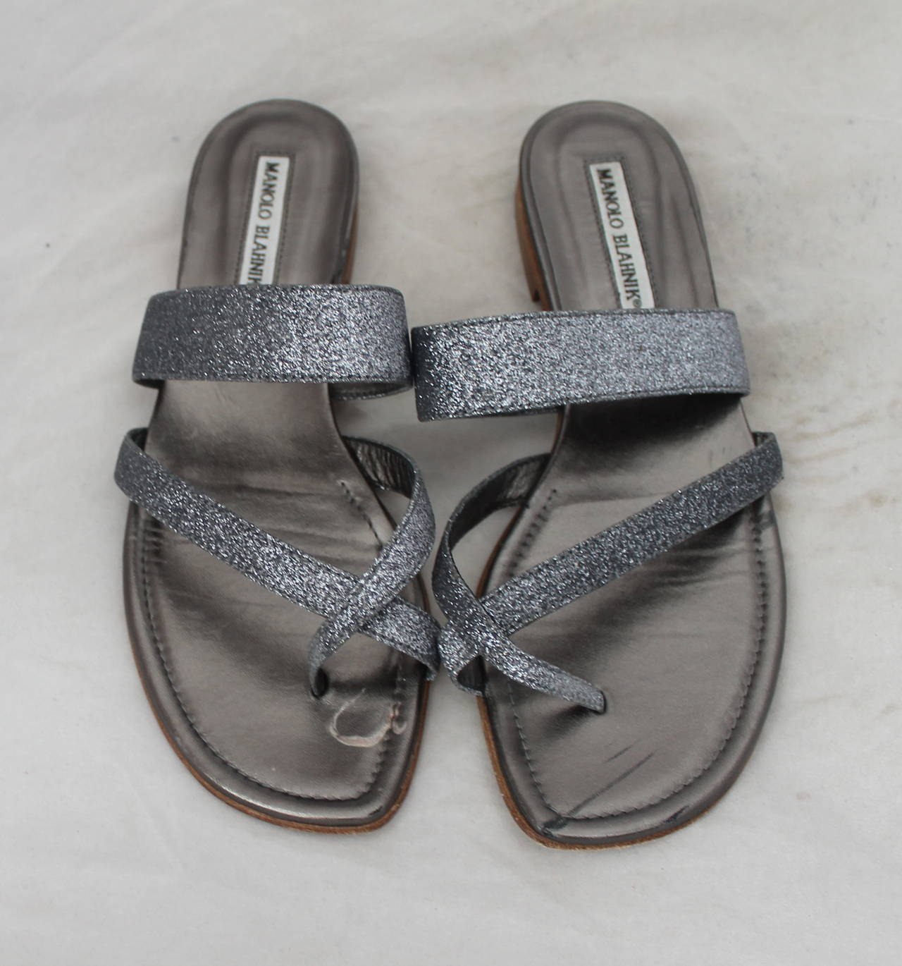 Manolo Blahnik Gunmetal Silver Glitter Sandals - 38.5. These sandals are in good condition and have some wear on the sole.