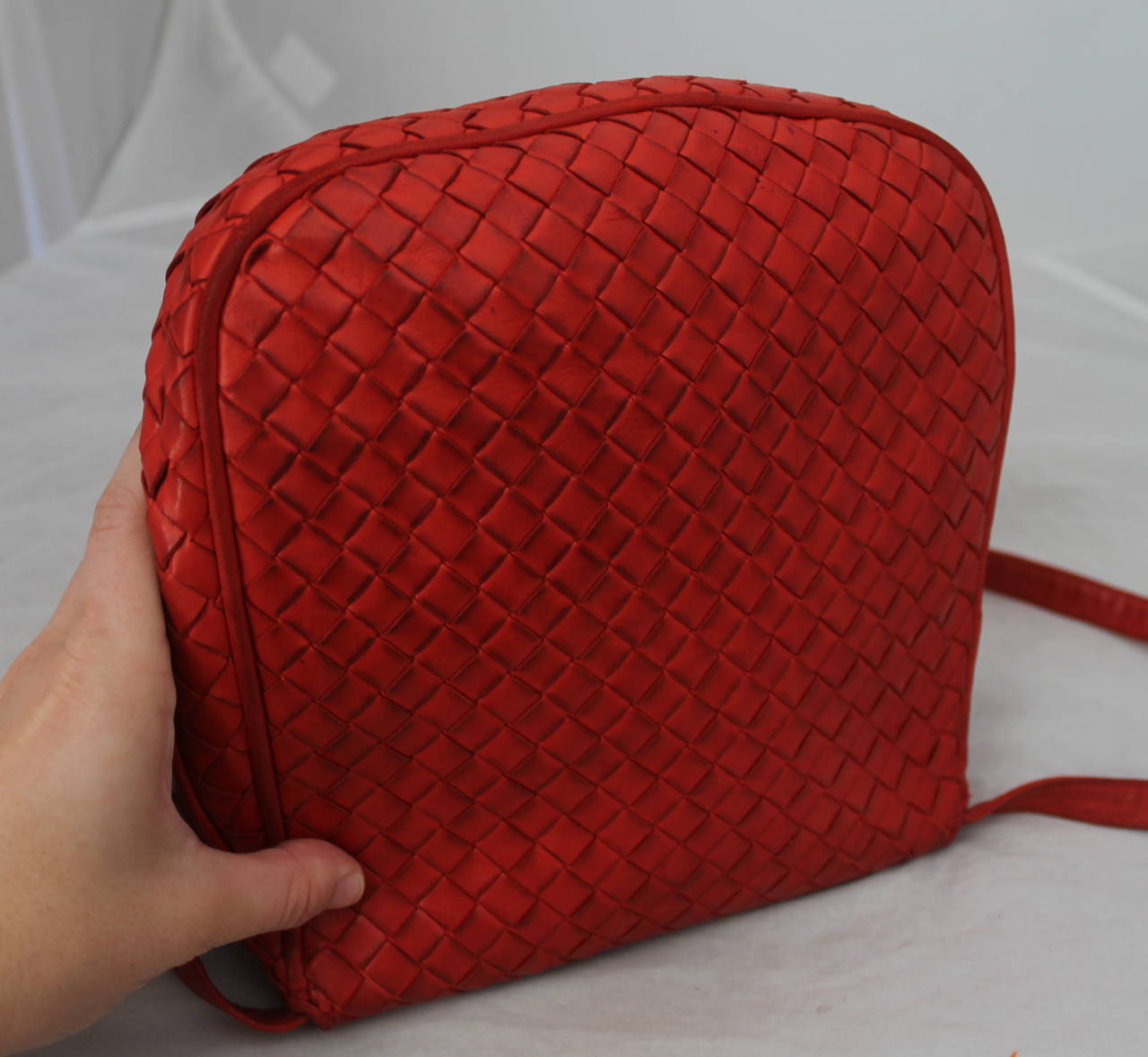 Bottega Veneta 1980's Vintage Red Braided Leather Crossbody Bag. This bag is in fair vintage condition with wear consistent with a 25 year old bag. The leather is dirty on the back of the bag and on the inside there is a pen mark on the top. The