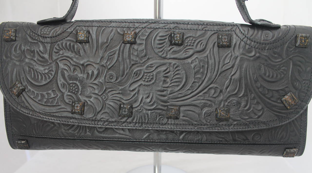Fendi Black Floral Embossed Leather Wide Handbag. This bag is in excellent condition with minor wear. It has a unique red lining.

Measurements:
Length- 7.5