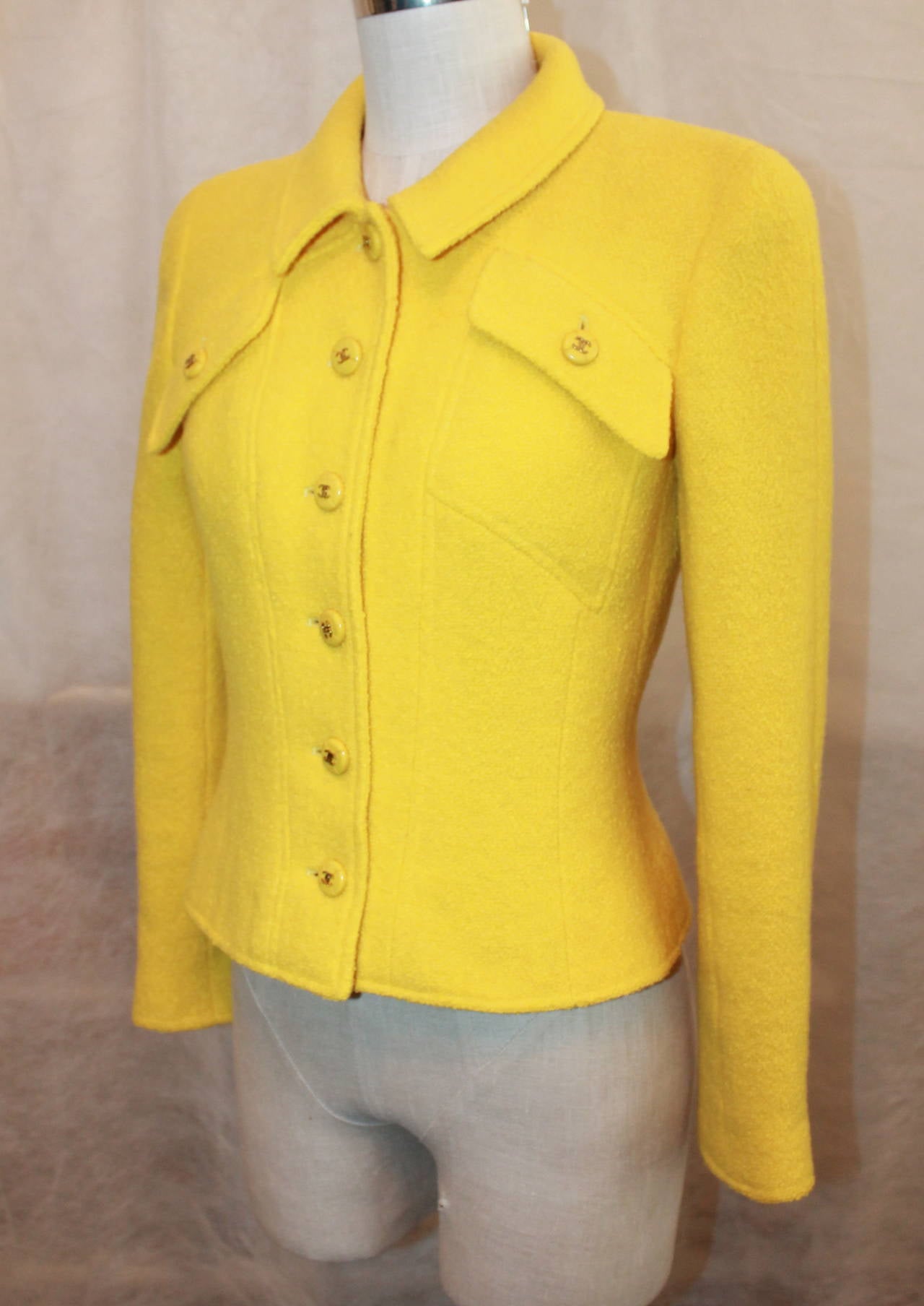 Chanel 1980's Yellow Tweed Single Breasted Jacket - 36. This jacket is in excellent vintage condition with light use. It has 6 buttons for closure and 2 flap pockets on the top of the jacket. It is 100% wool. 

Measurements:
Bust- 35