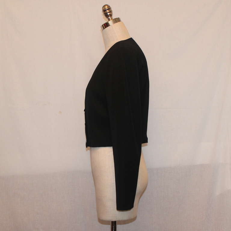 Chanel black double breasted cropped bolero-style jacket. This jacket has a wool fabric and a three button accent on the torso. It is in excellent condition. Circa 2000s. Size 40. 
Measurements:
Bust- 37"
Waist- 31"
Sleeve Length-