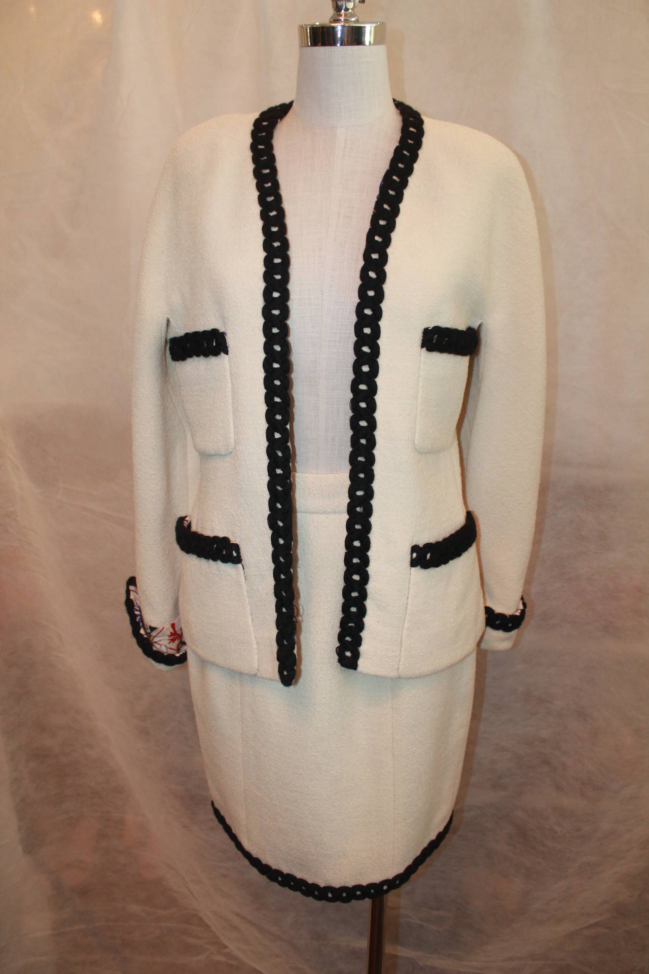 Chanel Ivory Wool Casino Theme Skirt Suit - Circa 80's-Sz 40 Black Crochet trim , Silk Print Casino Theme lining in jacket and skirt and interior of cuffs. 4 pocket front. This collectible suit is in good vintage condition.
Measurements:
Jacket: