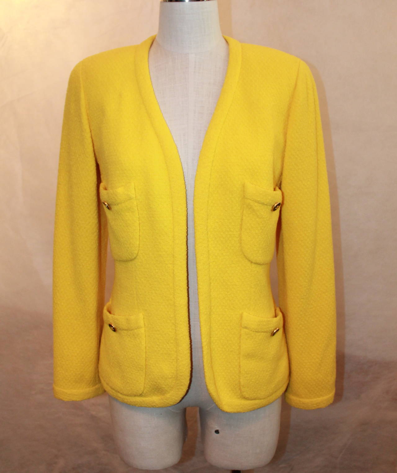 Chanel 1980's Vintage Yellow Tweed 4-Pocket Jacket - 38. This jacket is in very good condition and is 100% wool with a 100% silk lining. It has a button on each of the 4 pockets and no closure. 
**There is a matching skirt in
