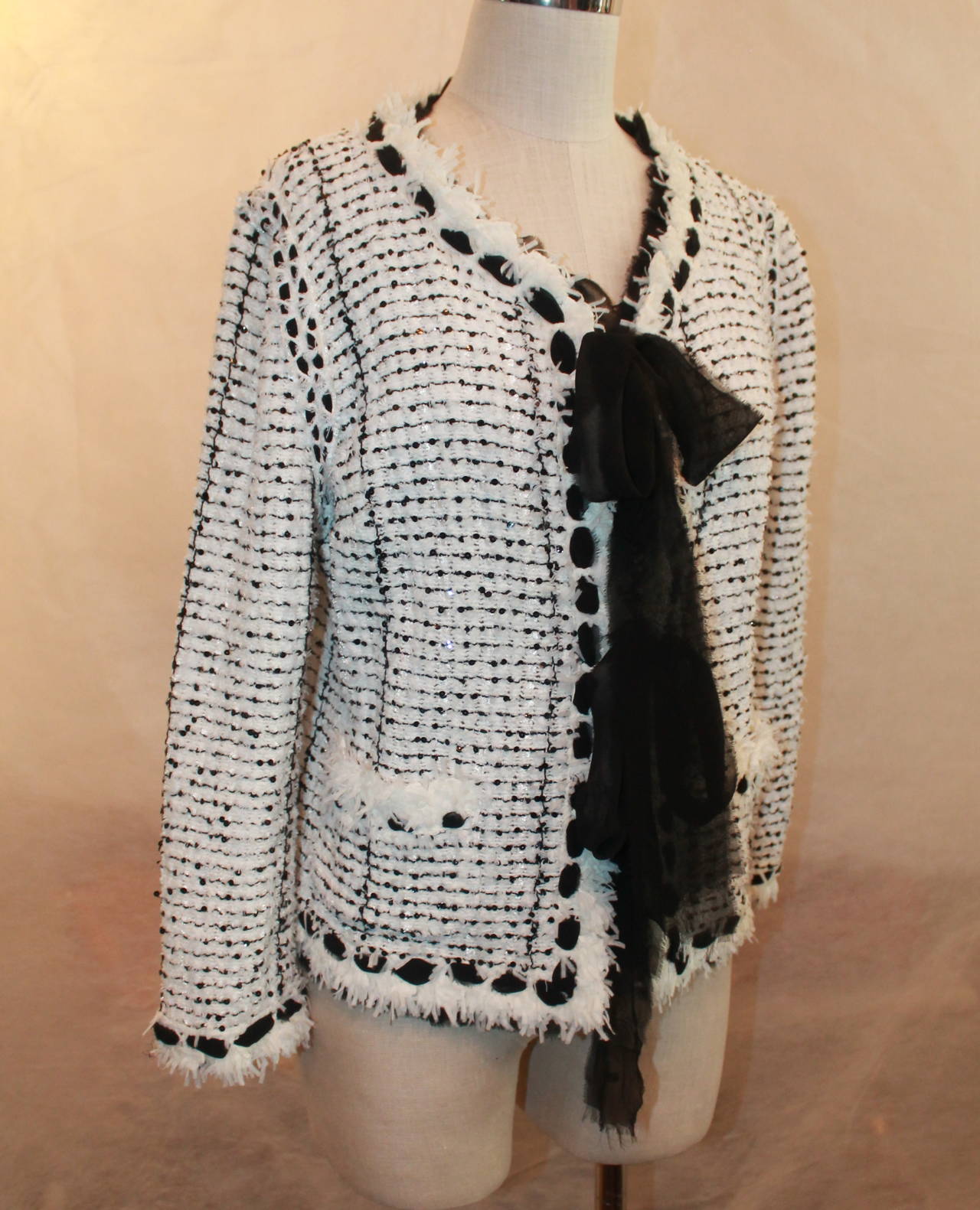 Chanel 2006 Black & White Tweed Sequin Jacket - 46. This jacket is in very good condition with a couple very minor pulls. It is a nylon, polyester, cotton, silk, and acetate blend. It has small black sequins on the black tweed and also a fringed