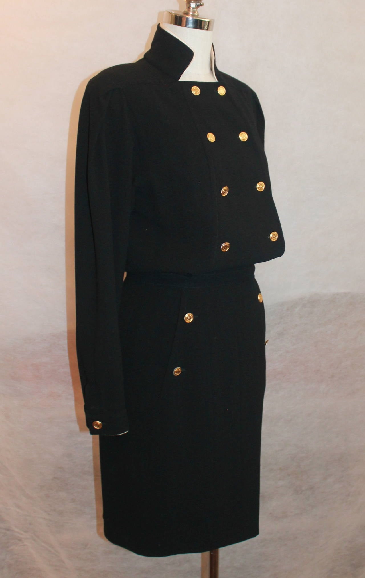 Chanel Black Wool Dress w/ Gold Front button detail - Circa 80's
This top part of this vintage dress is double breasted and has 8 front buttons, button detail on sleeve, and the skirt section has 2 side slit pockets with 2 button detail on each. By