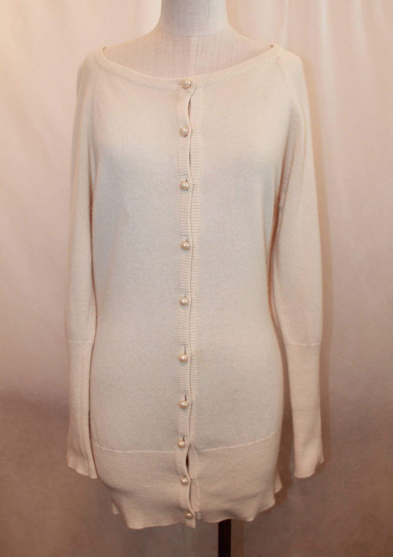 Chanel 1980's Vintage Creme Cashmere Sweater with Pearl Buttons - L. This sweater is in excellent vintage condition with very minor wear. It is 100% cashmere.

Measurements:
Bust- 36