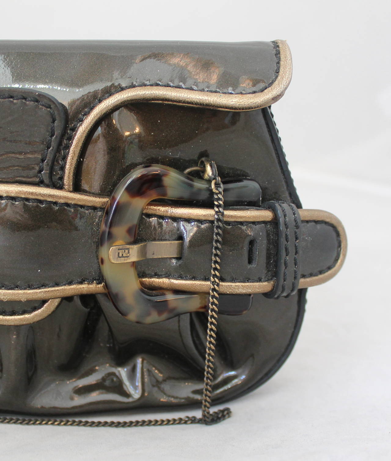 Fendi Deep Olive Patent Bag/Clutch with Tortoise Detail. This bag is in excellent condition and comes with a Fendi tag & card. The plastic is still on the inside label. The small golden chains are removable for a clutch option. Also, the bag has