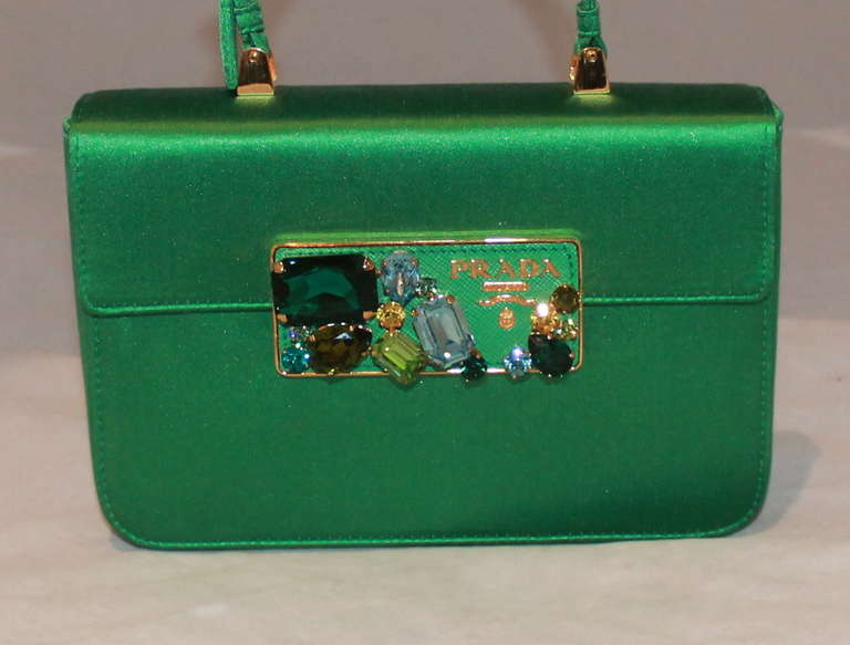 Prada green satin handbag with multi-color stone embellishment on front. Bag is in excellent condition and includes the card & duster. 
Measurements:
Height- 4.75