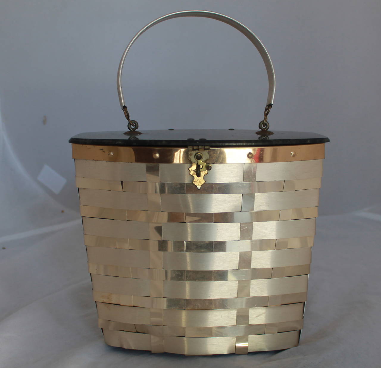 Goldstrom 1950s Vintage Goldtone Basket Weave with Grey Marbleized Top Bag. This bag is in fair vintage condition with wear consistent with its age. The inside has visible wear and there is some wear on the outside.

Measurements:
Height-