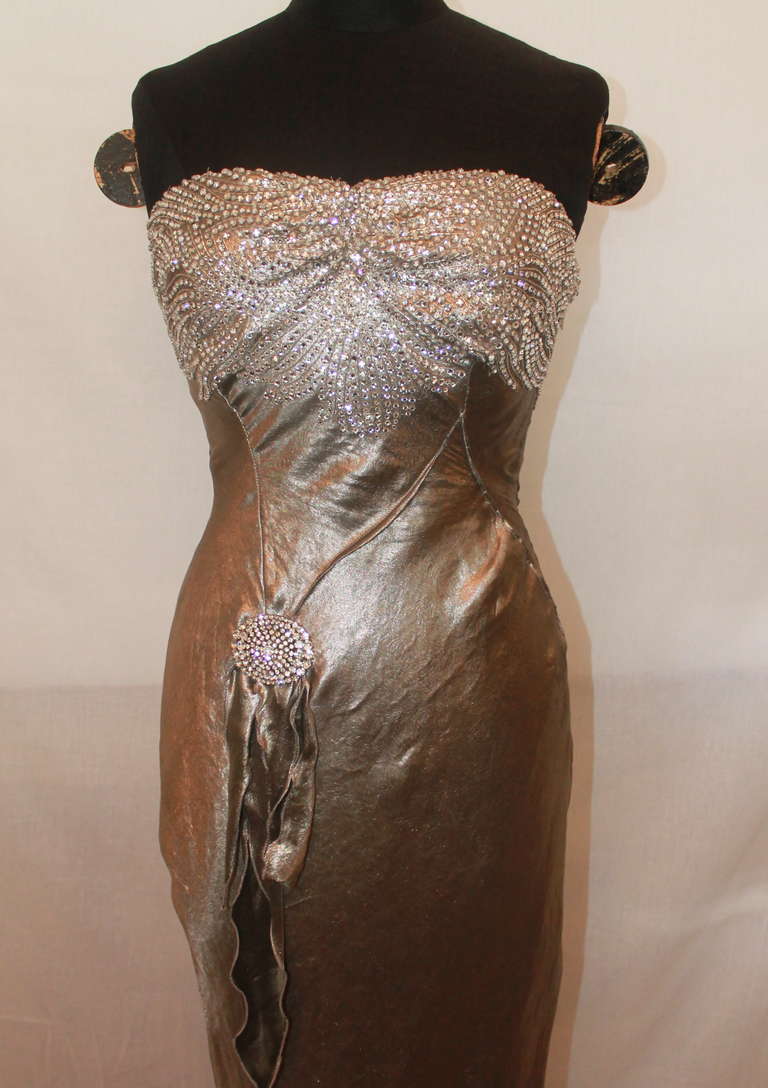 Ralph Lauren Couture Gunmetal Silk Lame Gown. This strapless gown has diamond details on the bust and a diamond pendent accent. It is in impeccable condition. Size 6.
Measurements:
Bust- 35.5