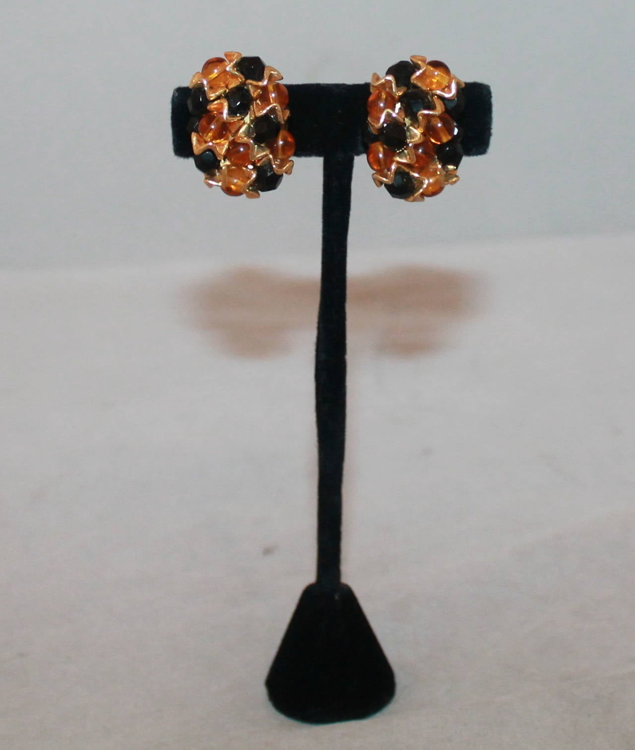 1960's Vintage Amber & Black Beaded Geometric Design Clip-ons. These earrings are in very good condition with wear consistent with age.

Length- 1