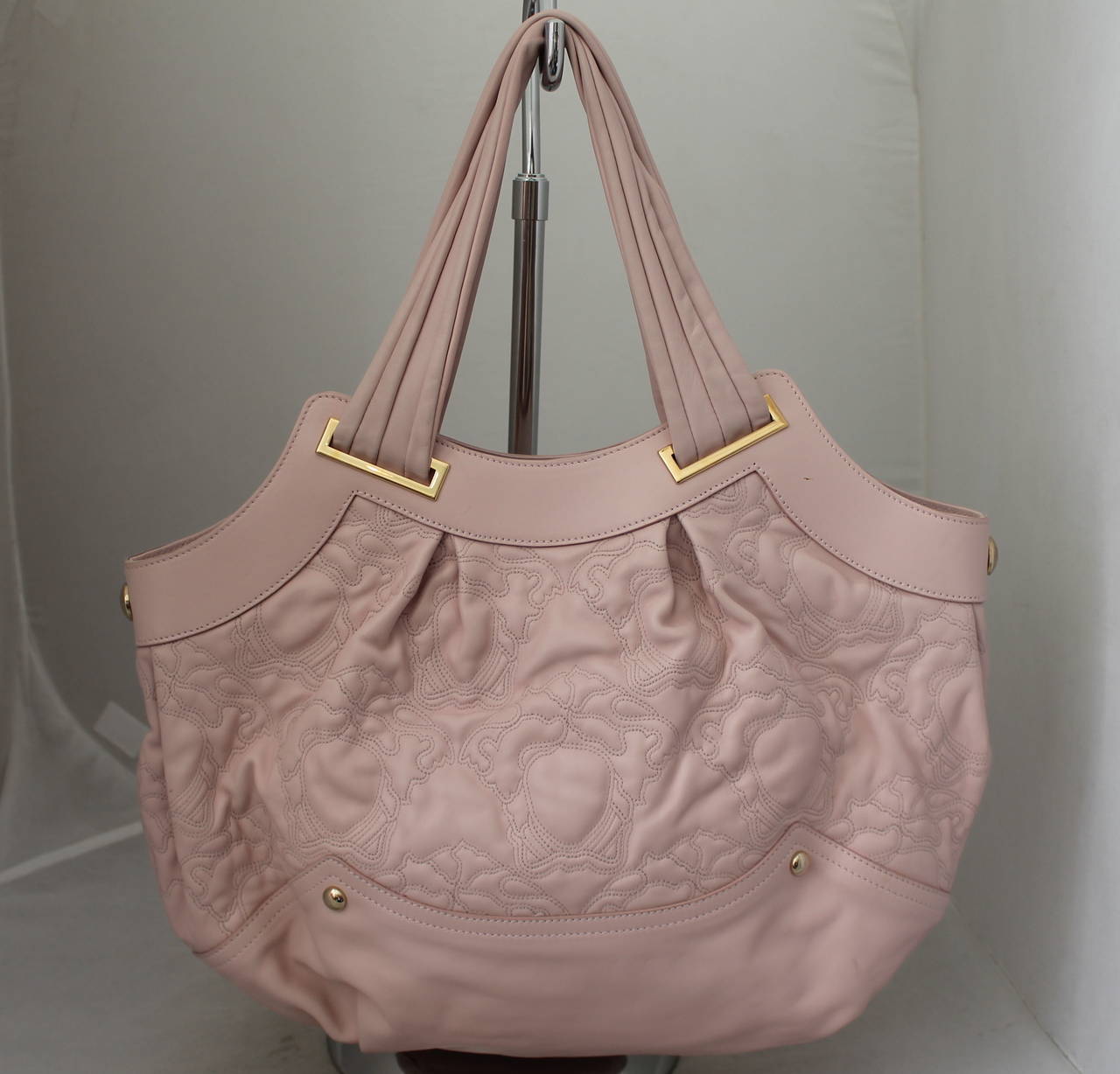 Versace Pastel Pink Motif-Themed Quilted Leather Shoulder Bag. This bag is in good condition with the only issues being that it has a few small markings shown in images 6-9. The hardware is a light gold tone and the bag has a satin lining.