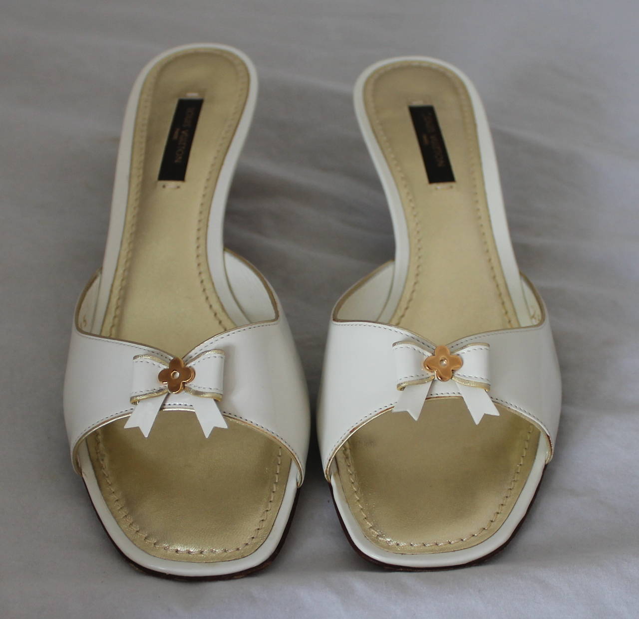 Louis Vuitton White Patent Slides with Bow & Kitten Heel - 38.5. These shoes are in very good condition with some wear, specifically on the bottom.