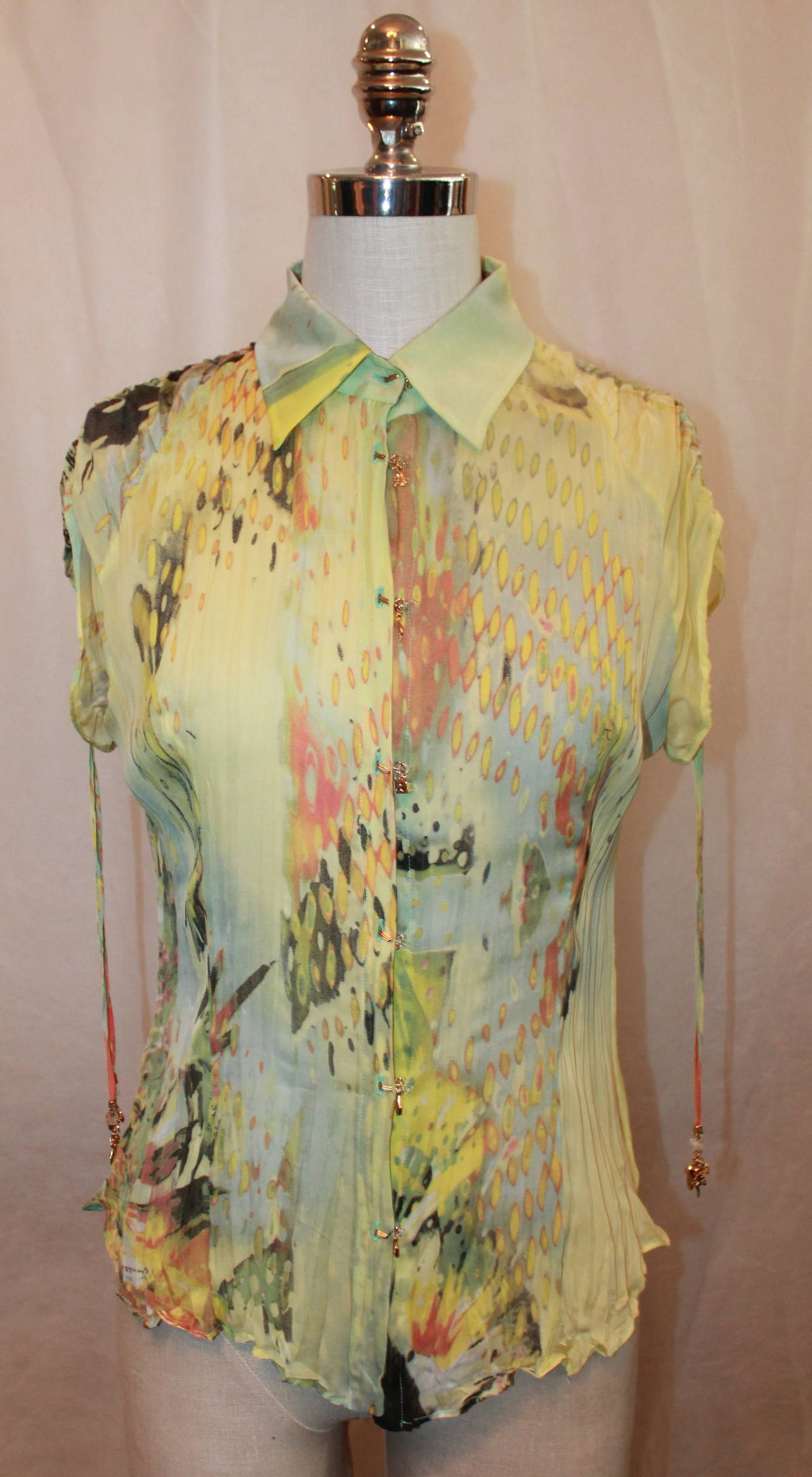 Roberto Cavalli Green Multi Color Tropical Print Silk Chiffon Short Sleeve Top with Goldtone Charms (Clover, Rabbit Foot, Dice, Hamsa, and Horse Shoe). This Top is in Excellent Condition, New With the Tags.

Measurements:
Bust: 40 