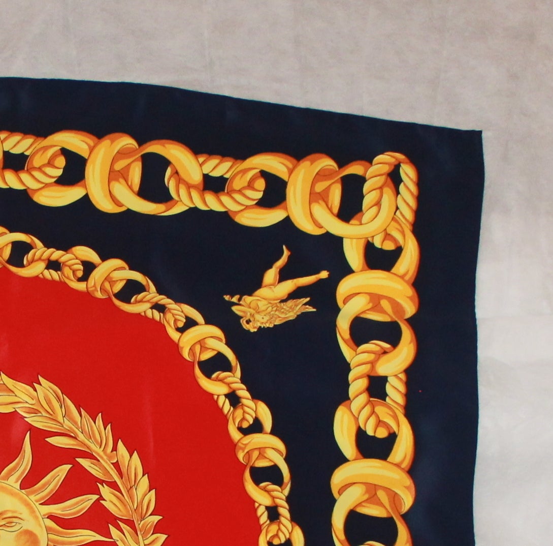 Versace Red, Gold, and Navy Silk Chain Print Scarf with Sun Motif and Cherubs in Excellent Condition.

Measurements:
Length: 34.25 