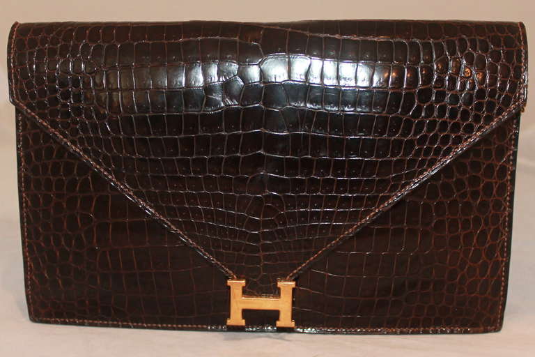 Hermes Shiny Marron Fonce Porosus Crocodile Lydie Clutch - 1982 - GHW, Detachable cross body strap, minor scratch on H...otherwise it is in excellent vintage condition.
Measurements:
Length- 9.75