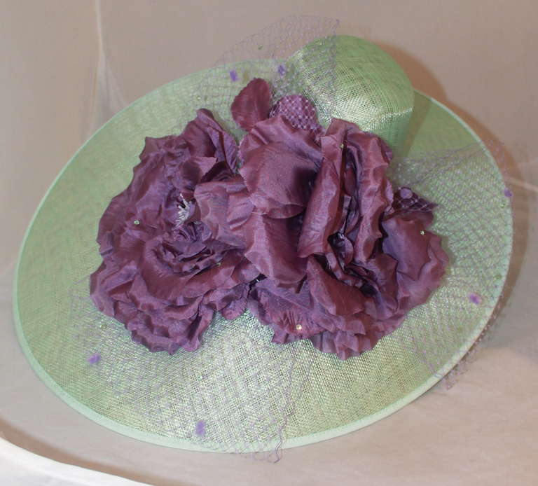 Herald & Heart Mint Straw Ascot with Lavender Flower Accent. This headband hat is asymmetrical and cover 3/4 of the head. The flowers have lavender tuille and purple rhinestone accents.
Measurements:
Circumference- 53
