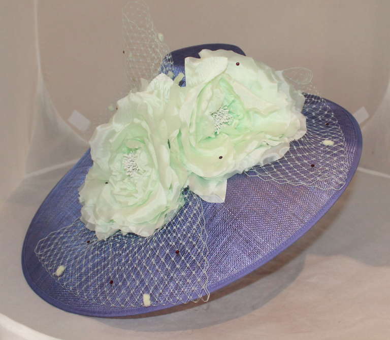 Herald & Heart Lavender Straw Ascot with Mint Flower Accent. This headband hat has mint tuille and mint rhinestones. It is an asymmetrical hat that covers 3/4 of the head. It is brand new. 
Measurements:
Circumference- 53