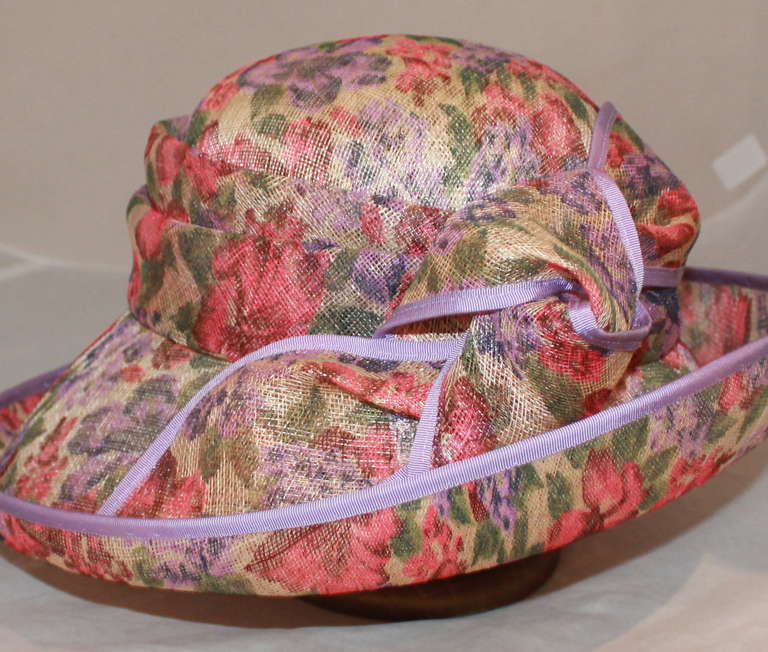 Herald & Heart Floral Print Sloop Style Hat. This hat is in the 1900-1905 style and is edged in lavender grograin. It has a straw bow and is a new, current piece.
Measurement:
Circumference- 45