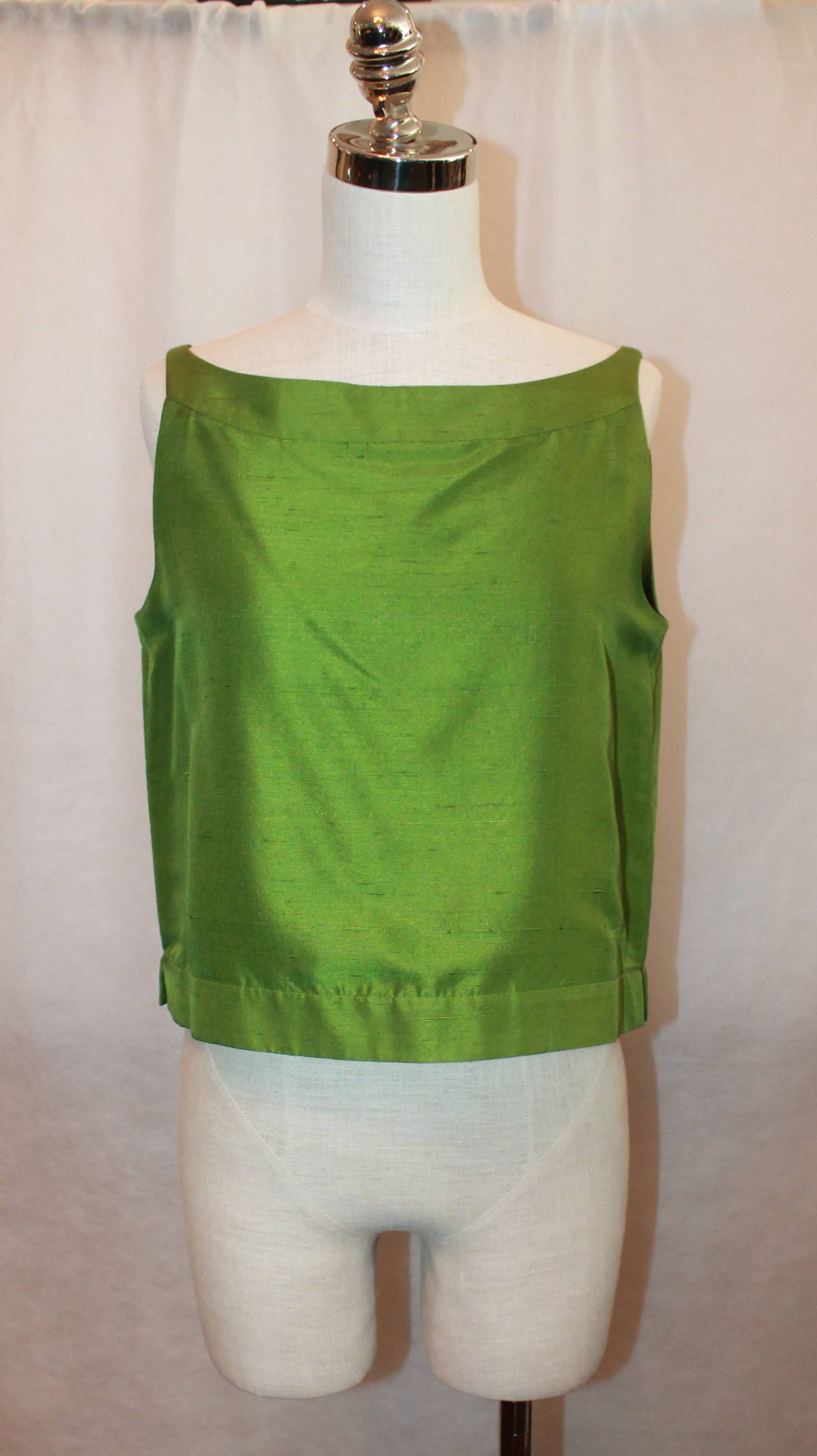 This Oscar de la Renta Green Silk Sleeveless Top is a size 8, is from the 90's and is in excellent condition. The top has a beautiful neckline and has a keyhole opening in the back with 2 silk covered buttons. It is not a crop top but is somewhat