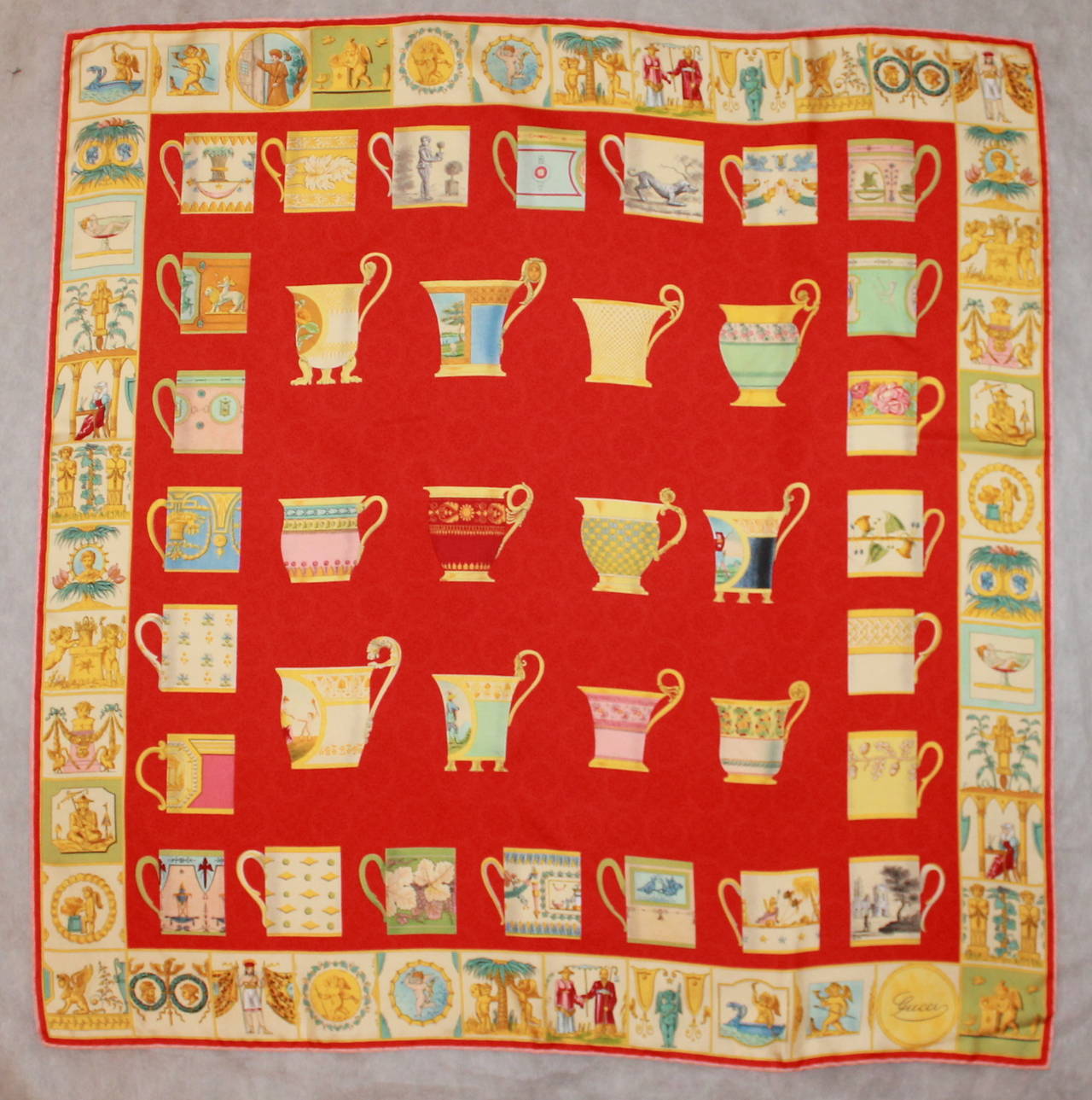 Gucci Red Tea Cup Printed Silk Scarf. This scarf is in excellent condition and has a courtly themed print trim. 

Length- 33.5