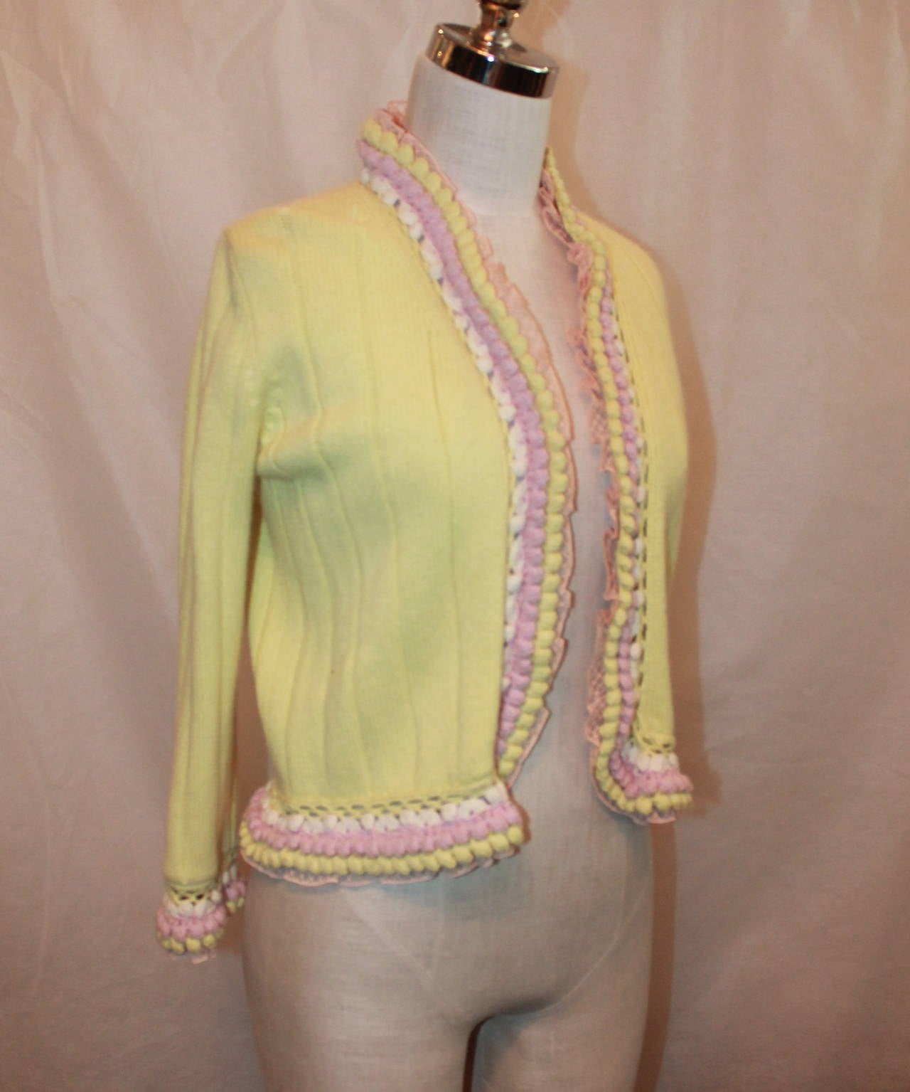 Chanel 2004 Yellow & Pink Cashmere Cardigan - 38. This cable knit cardigan is in excellent condition and has an embellished trim on the edges and sleeve cuffs. 

Measurements:
Bust- about 37