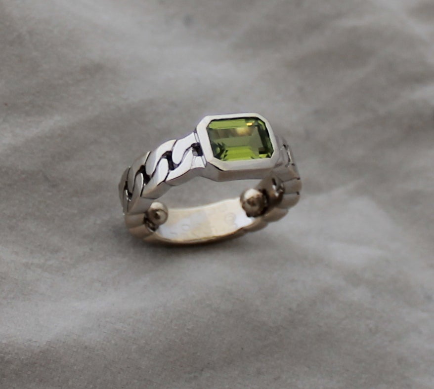 Chanel 18K White Gold Chain Ring with Green Citrine Stone. This ring is in excellent condition. There were 2 balls put into this ring in order for it to fit a smaller size finger. 

Circumference with balls- about 1.75