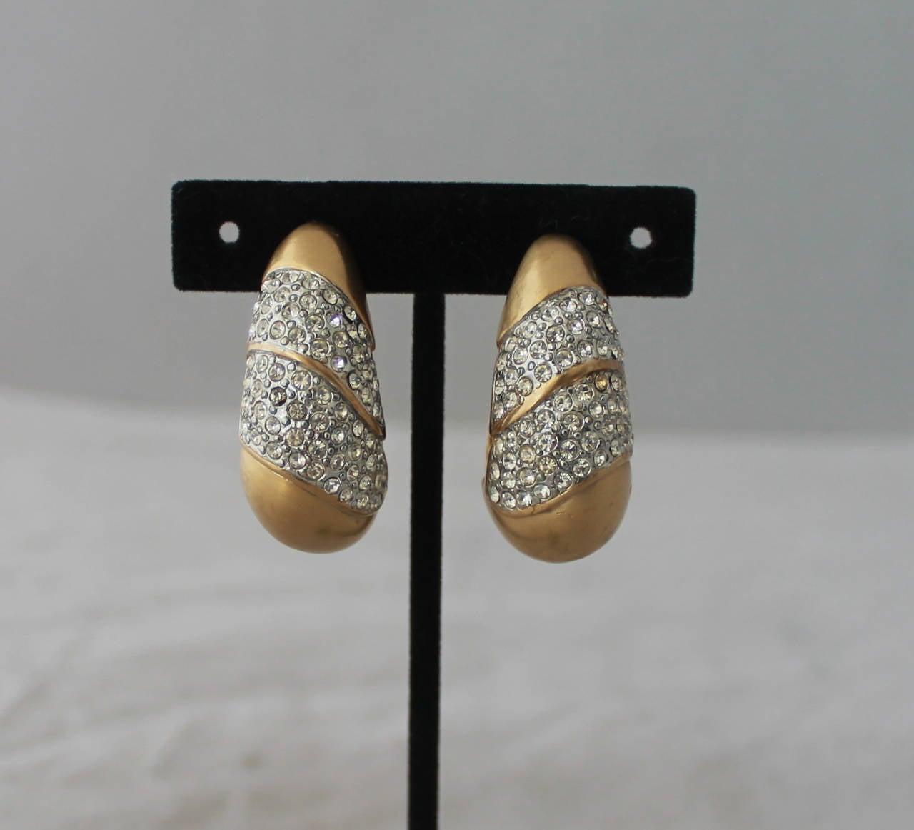 Les Bernard 1980's Vintage Goldtone & Rhinestone Clip-on Hoops. These hoops are in very good vintage condition with minor discoloring on the rhinestones on one of the hoops
.
Length- 1.75