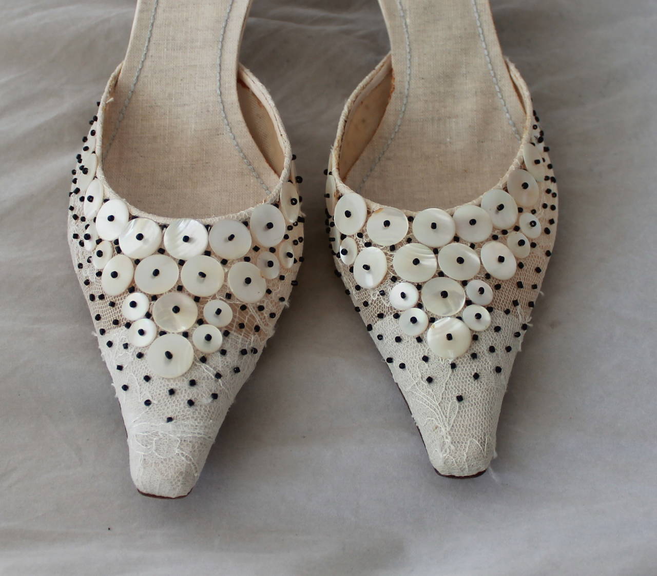 Rene Caovilla Ivory Lace & Mother of Pearl Beaded Heels - 40. This heels are in excellent condition and have never been worn, however there is some markings on the inside due to age (image 4). The shoe has a pointed toe with a low heel. The bottom