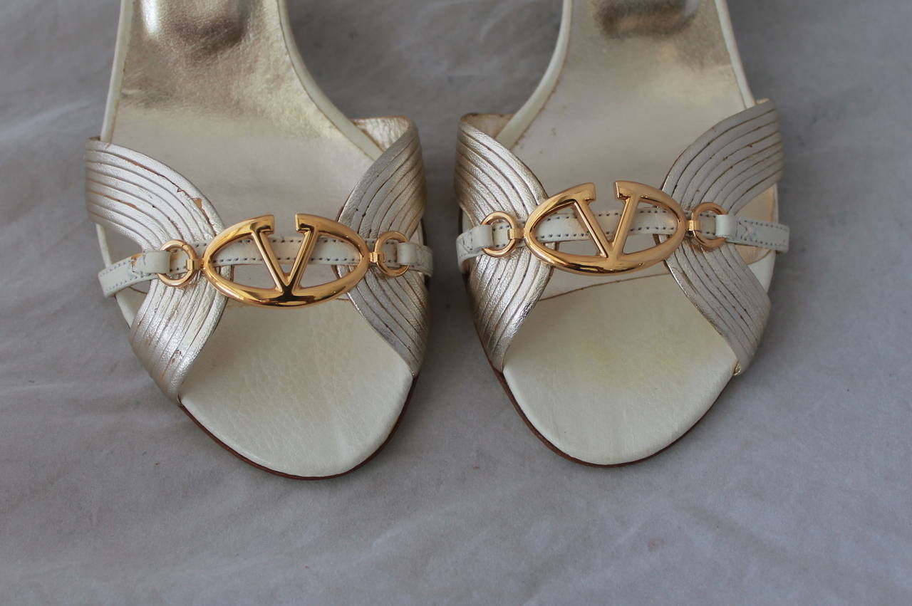 Valentino Gold Metallic Leather Sandals with Gold Logo - 37. These shoes are in fair condition with some wear on the bottom with chipping and markings on the gold leather on one shoe (image 3).