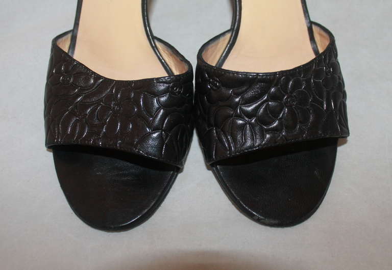 Chanel Black Monochromatic Slide Heel. The shoe has a floral & 