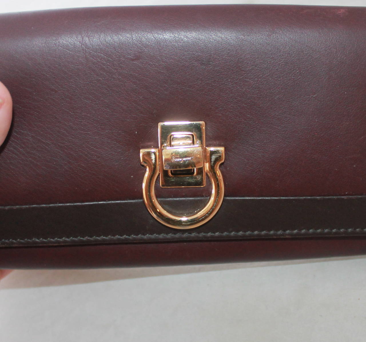 Salvatore Ferragamo Eggplant Leather Wallet with Box GHW. This wallet is in fair condition due to visible wear on the back (some scuffing on bottom, image 3) and minor wear on the front. There is some scuffing inside from use. This wallet is an