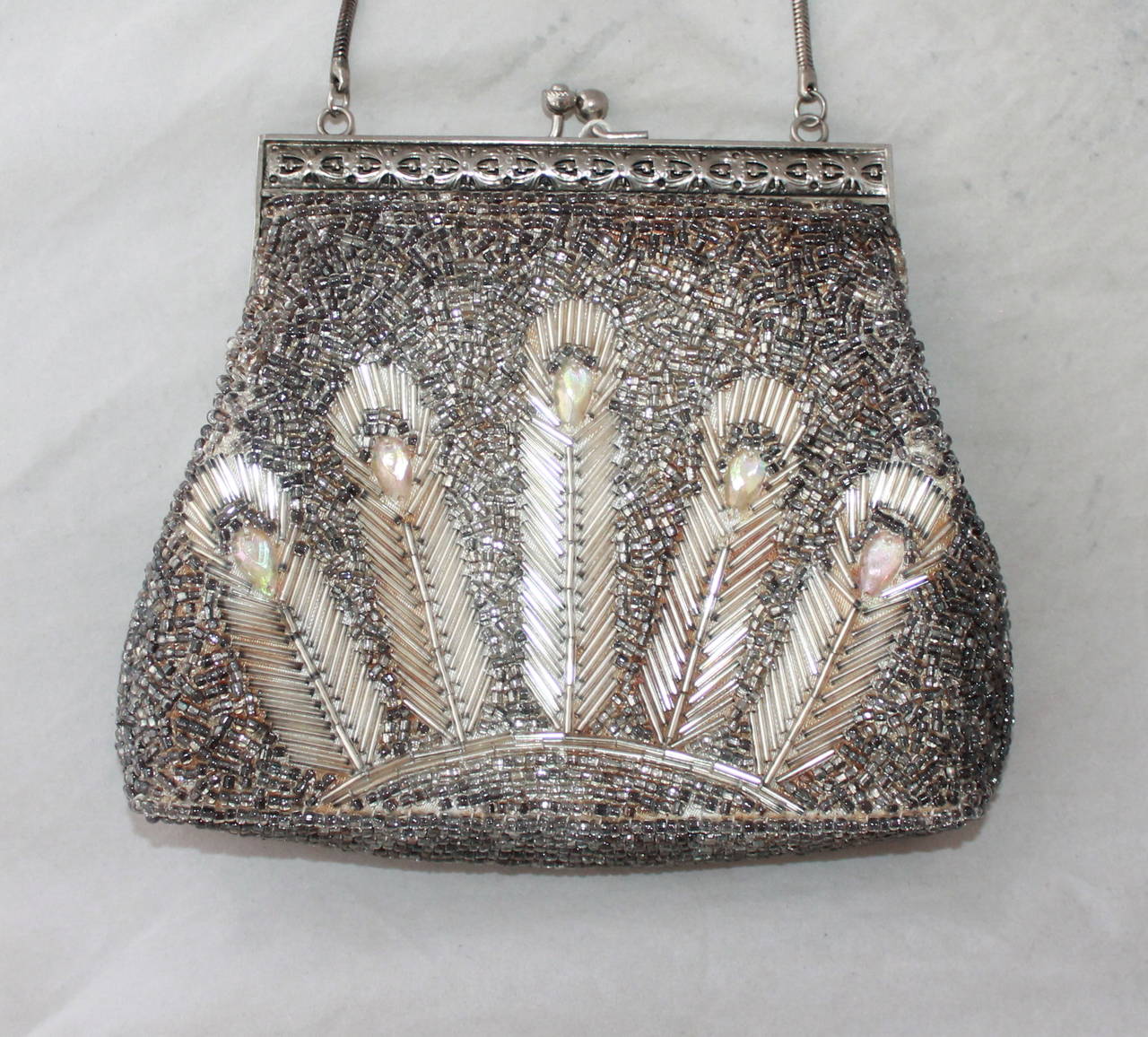 Art Deco Vintage Silver Peacock Feather Beaded Handbag. This bag is in excellent vintage condition and only has slight discoloring on the fabric under the beads from its age. The handle is thought to be sterling silver. 

Height- 5.25